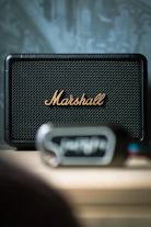 Black marshall speaker with gold logo on table