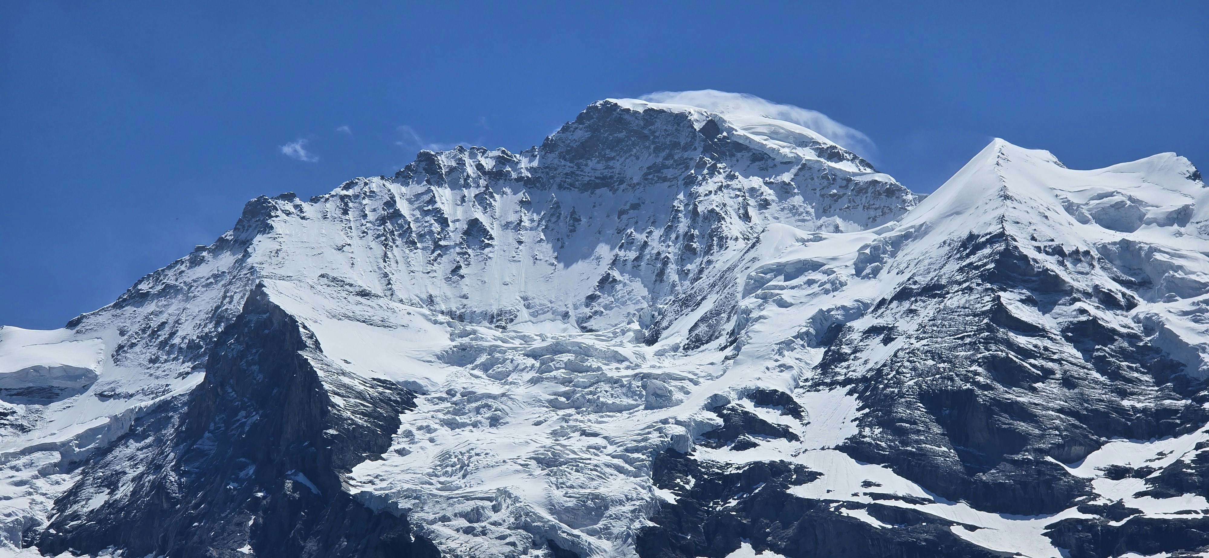 Snow-covered mountain peaks under a clear blue sky.