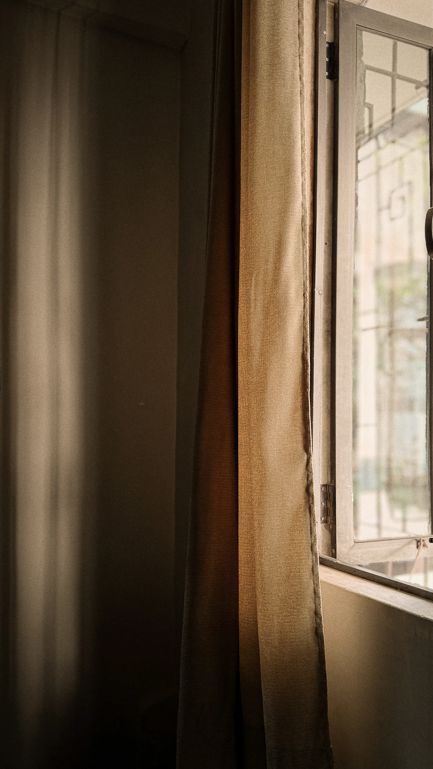 Linen curtains beside an open window, warm daylight coming through