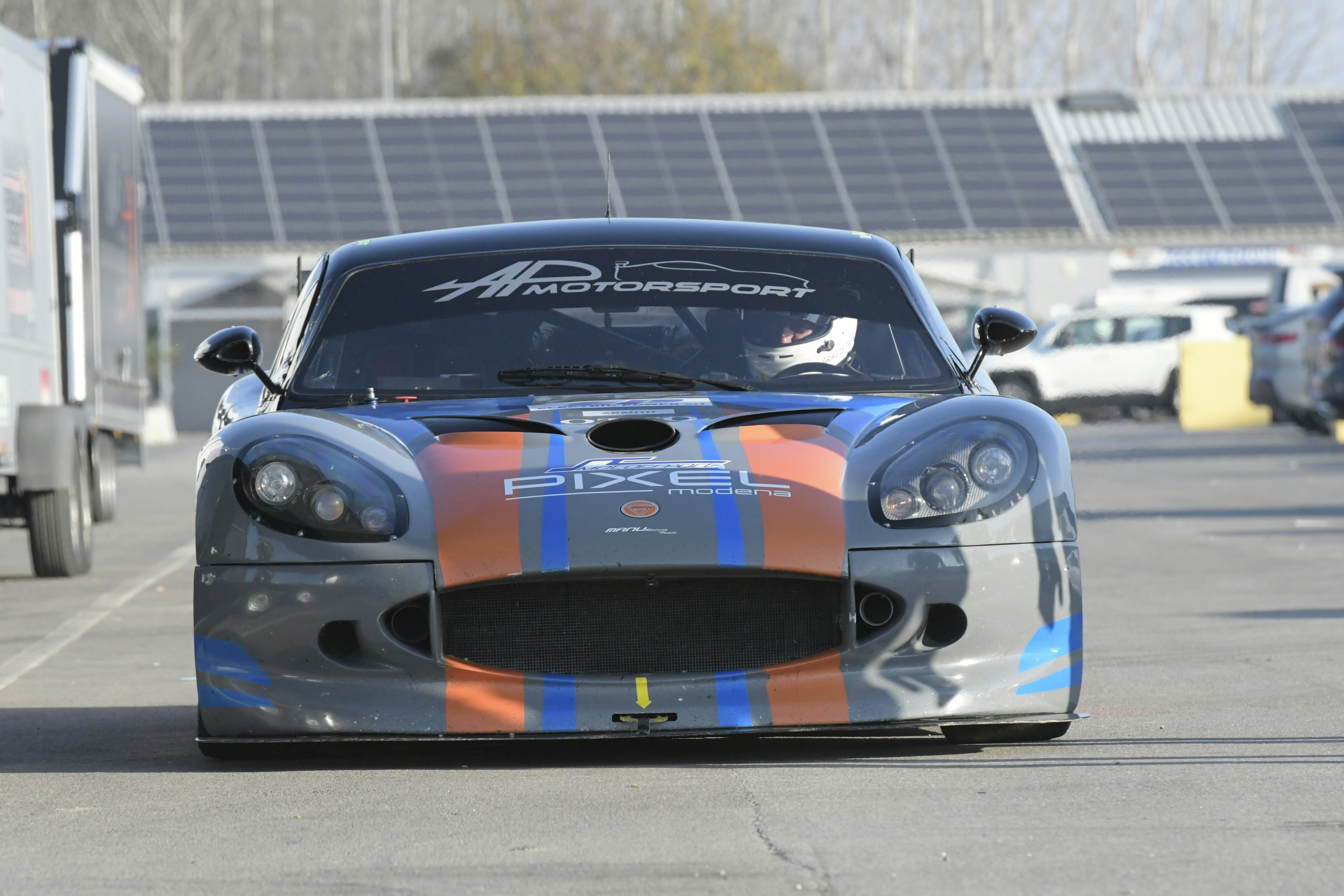 A race car with colorful stripes on a track.