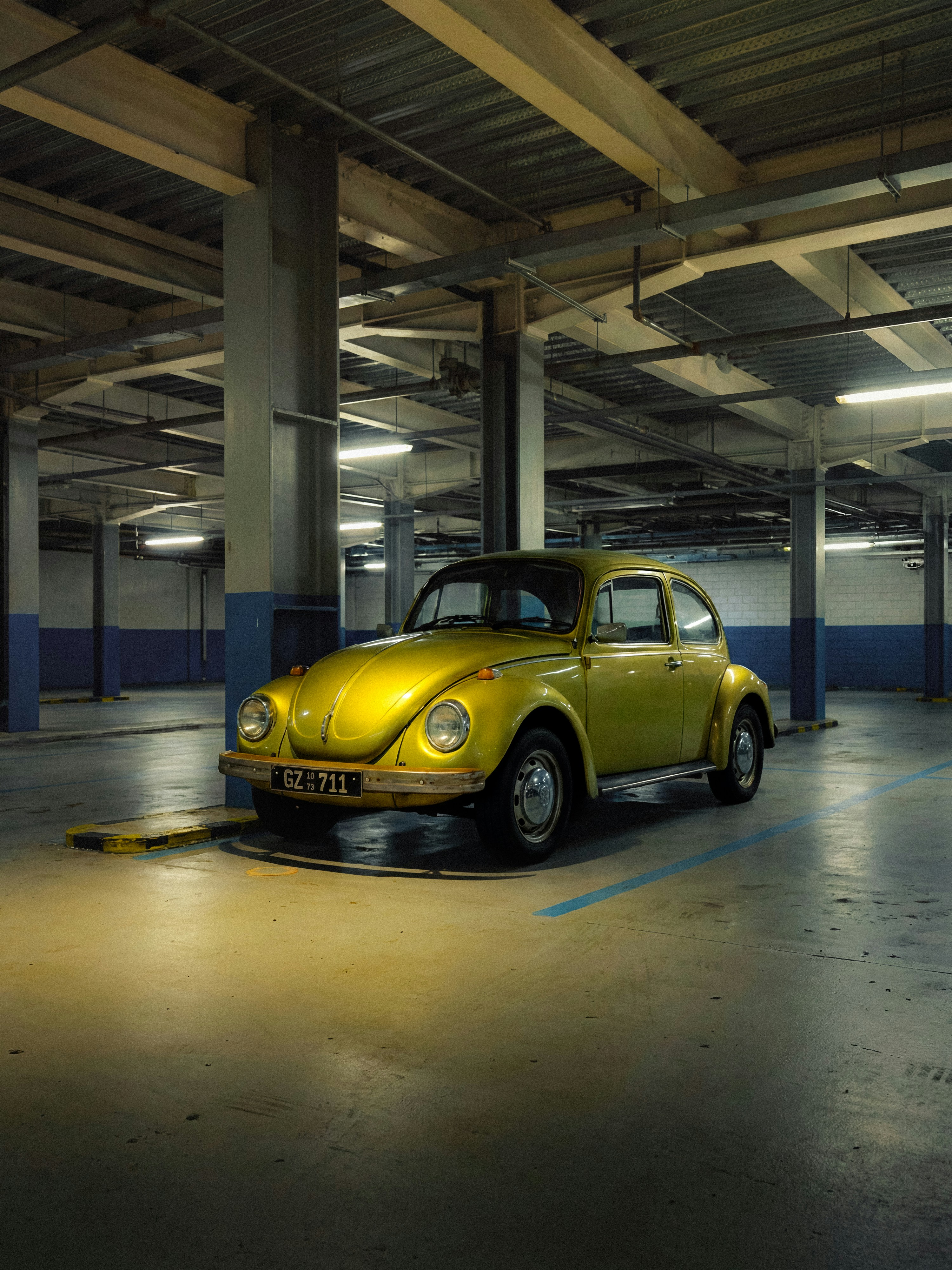 Yellow volkswagen beetle parked in a garage.
