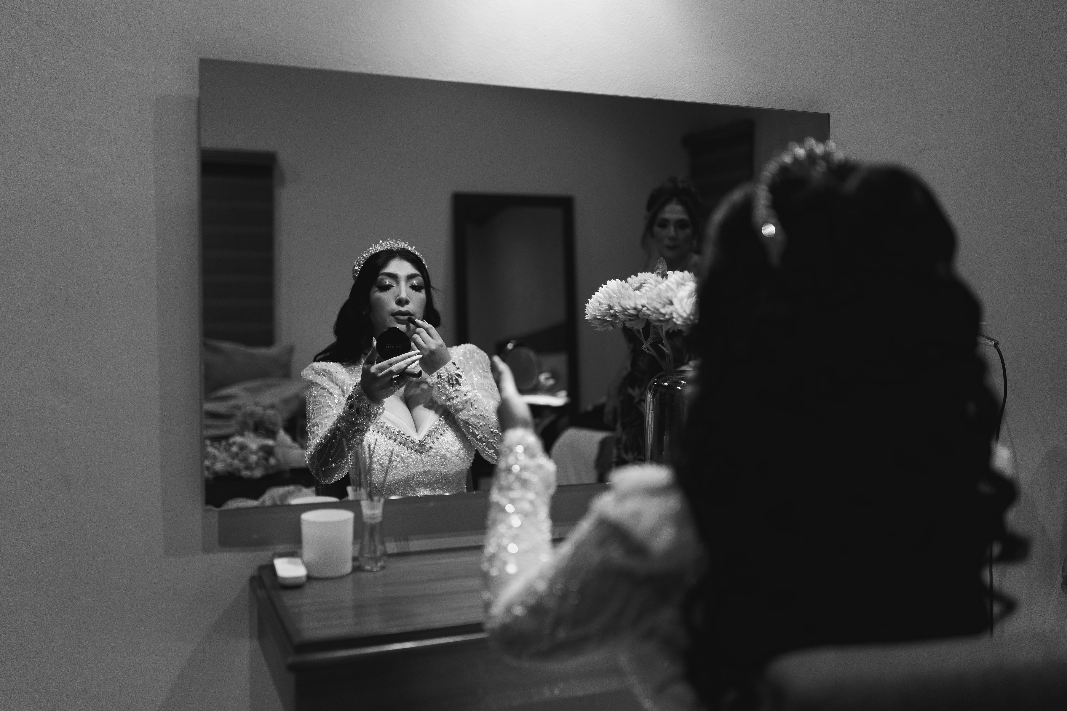 Bride applying lipstick in mirror before wedding