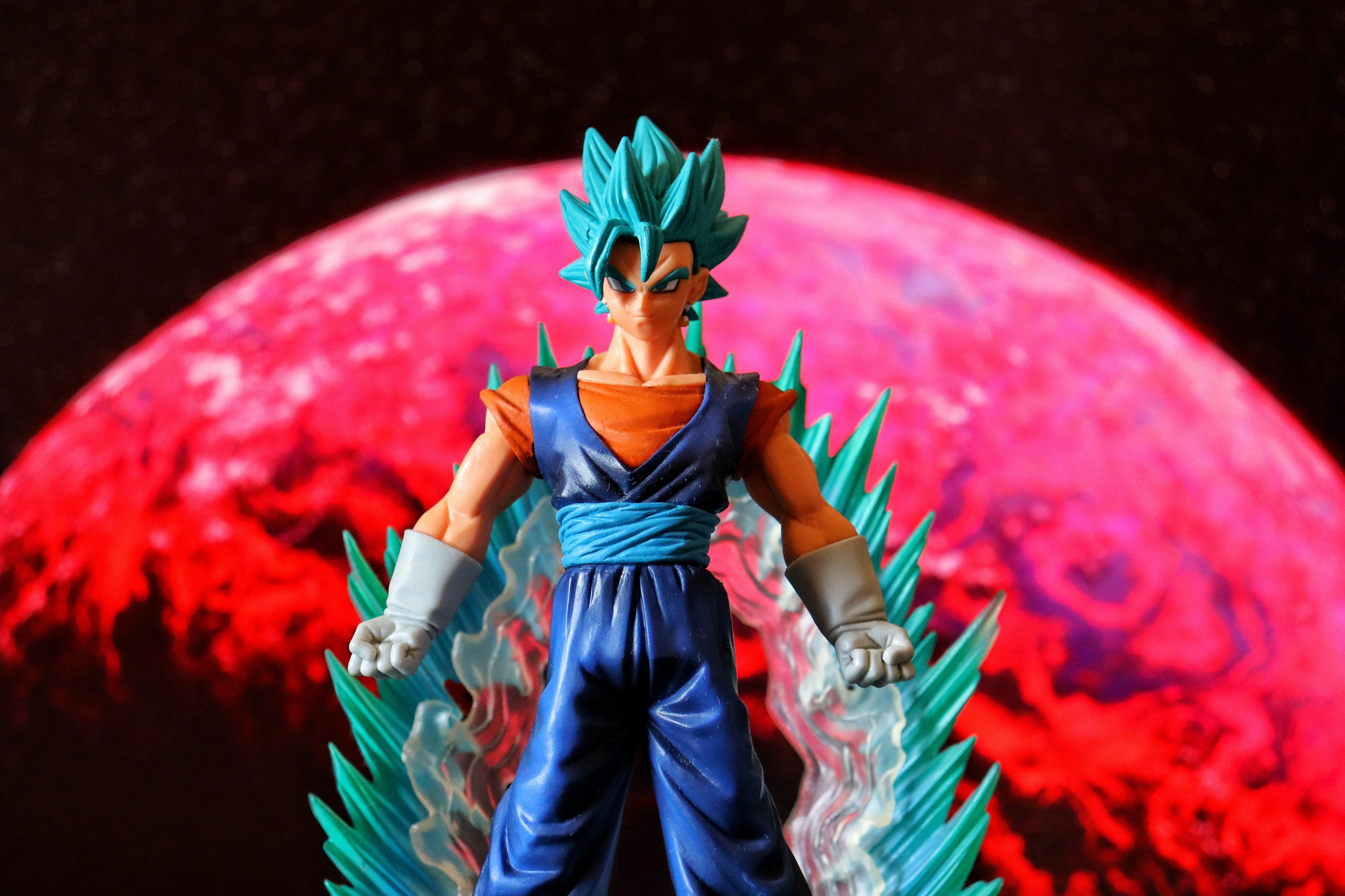 Personagem de anime de cabelos azuis com aura flamejante e planeta vermelho