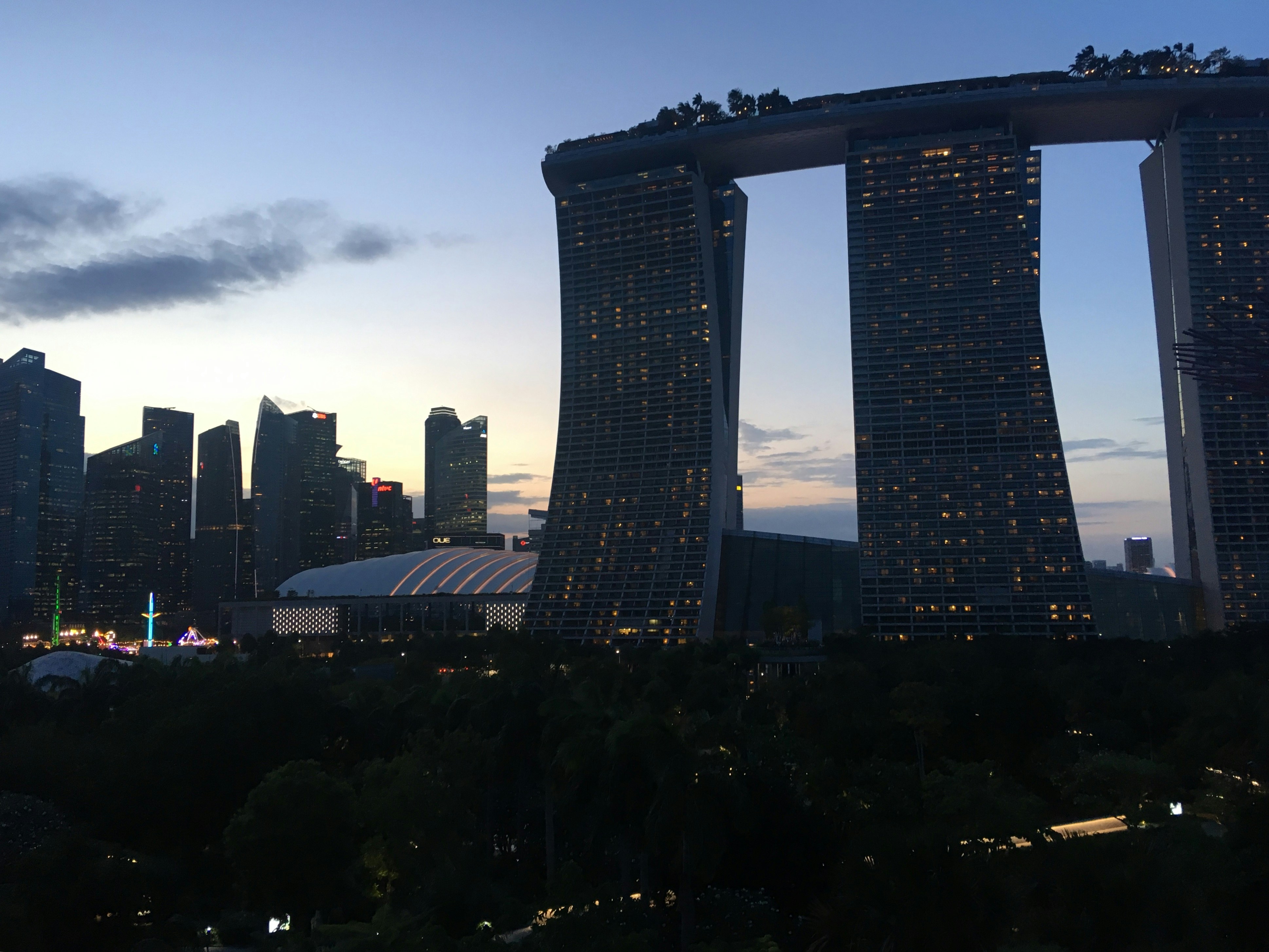 Skyscrapers at dusk with a cloudy sky.