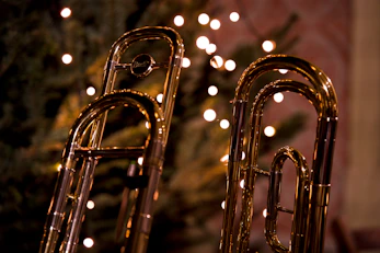 Two trombones in front of a blurred christmas tree