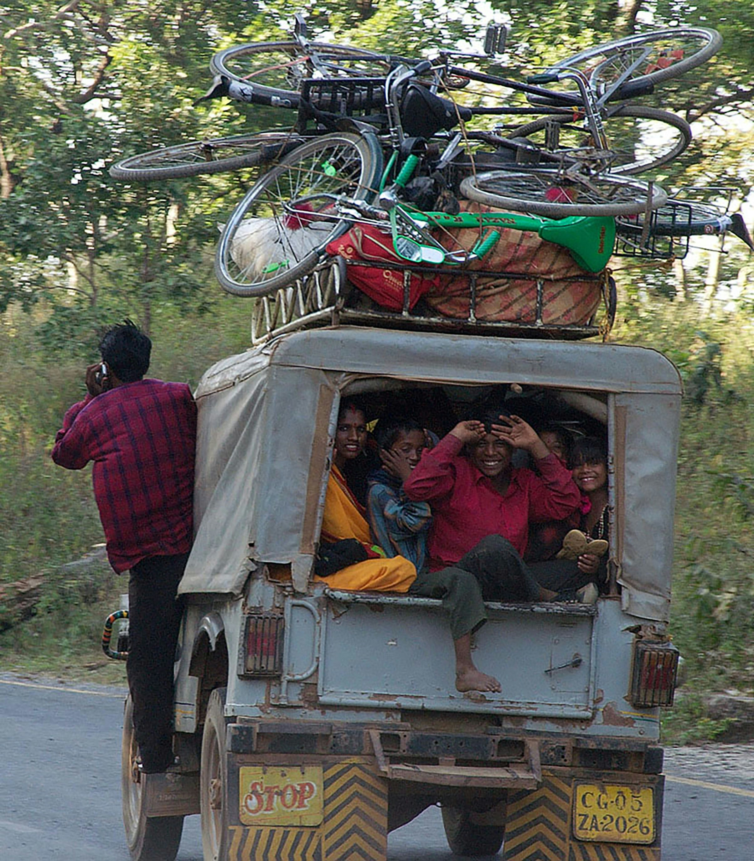 Menschen und Fahrräder auf ein Fahrzeug gepackt