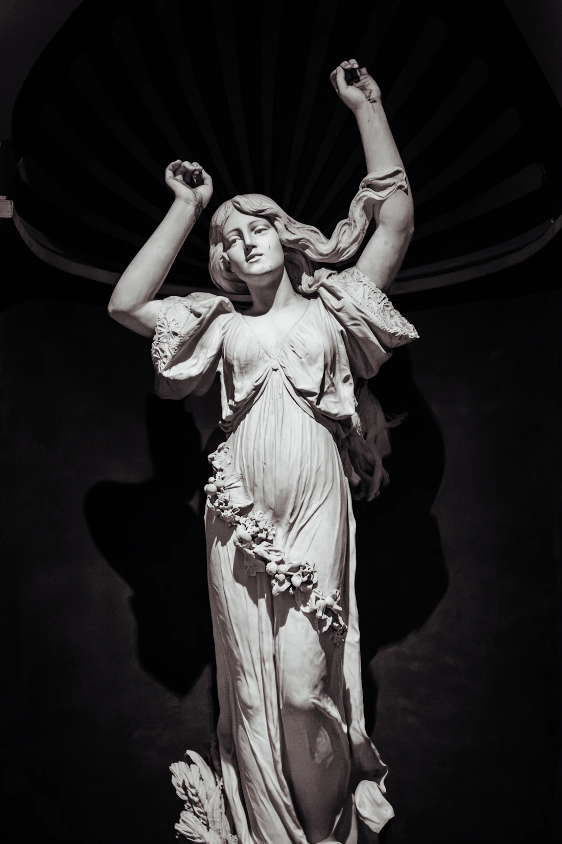 Expressive marble sculpture of a woman with raised arms in Hyderabad, India
