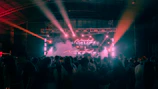 Concert stage with lights and smoke, crowd watching