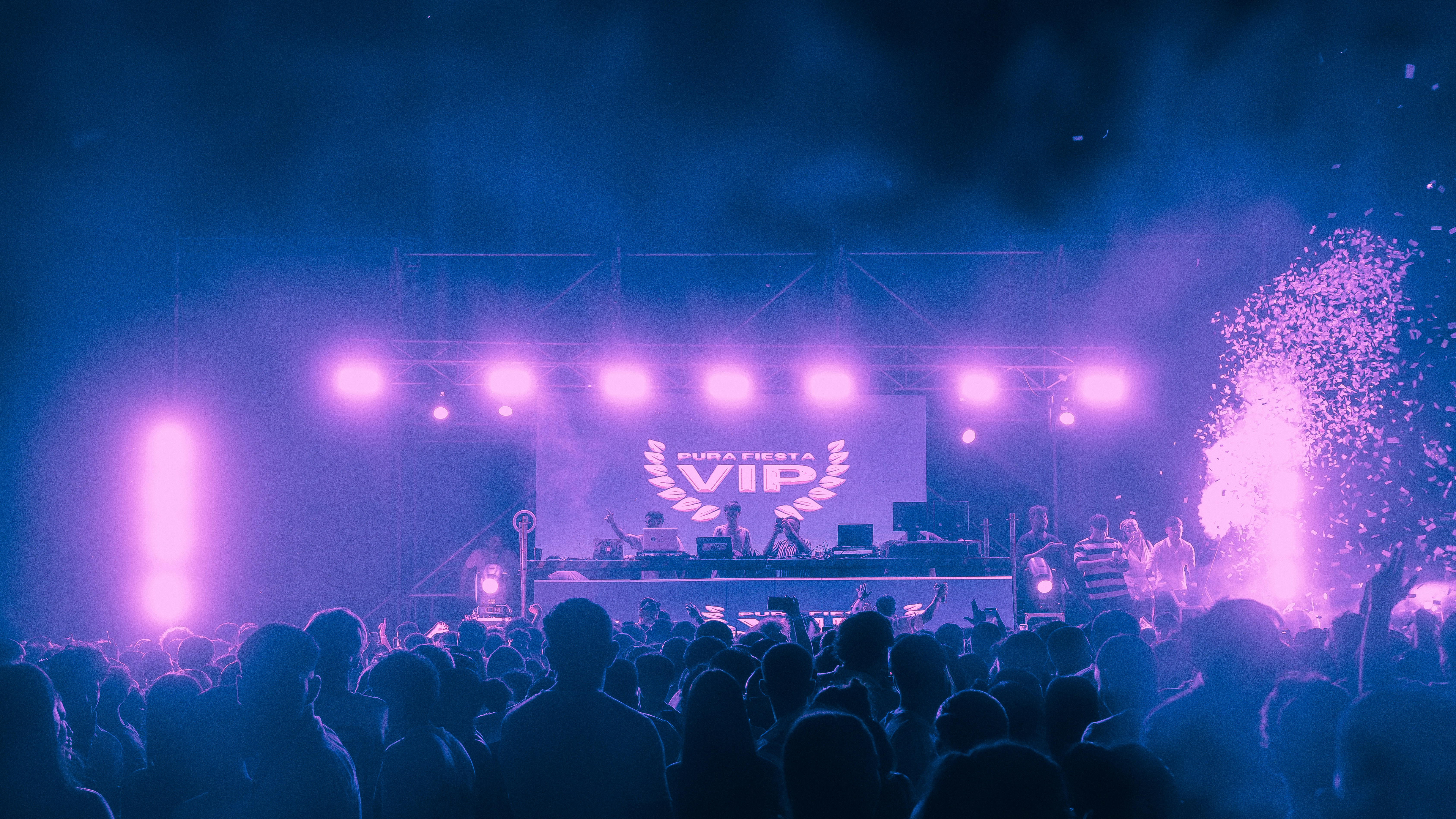 Crowd enjoying a concert with purple stage lights