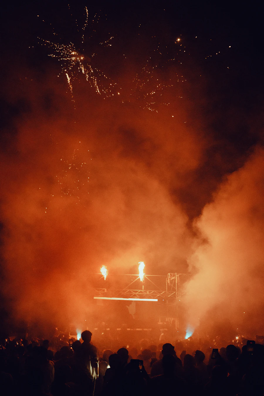 Fireworks bursting above an outdoor concert stage