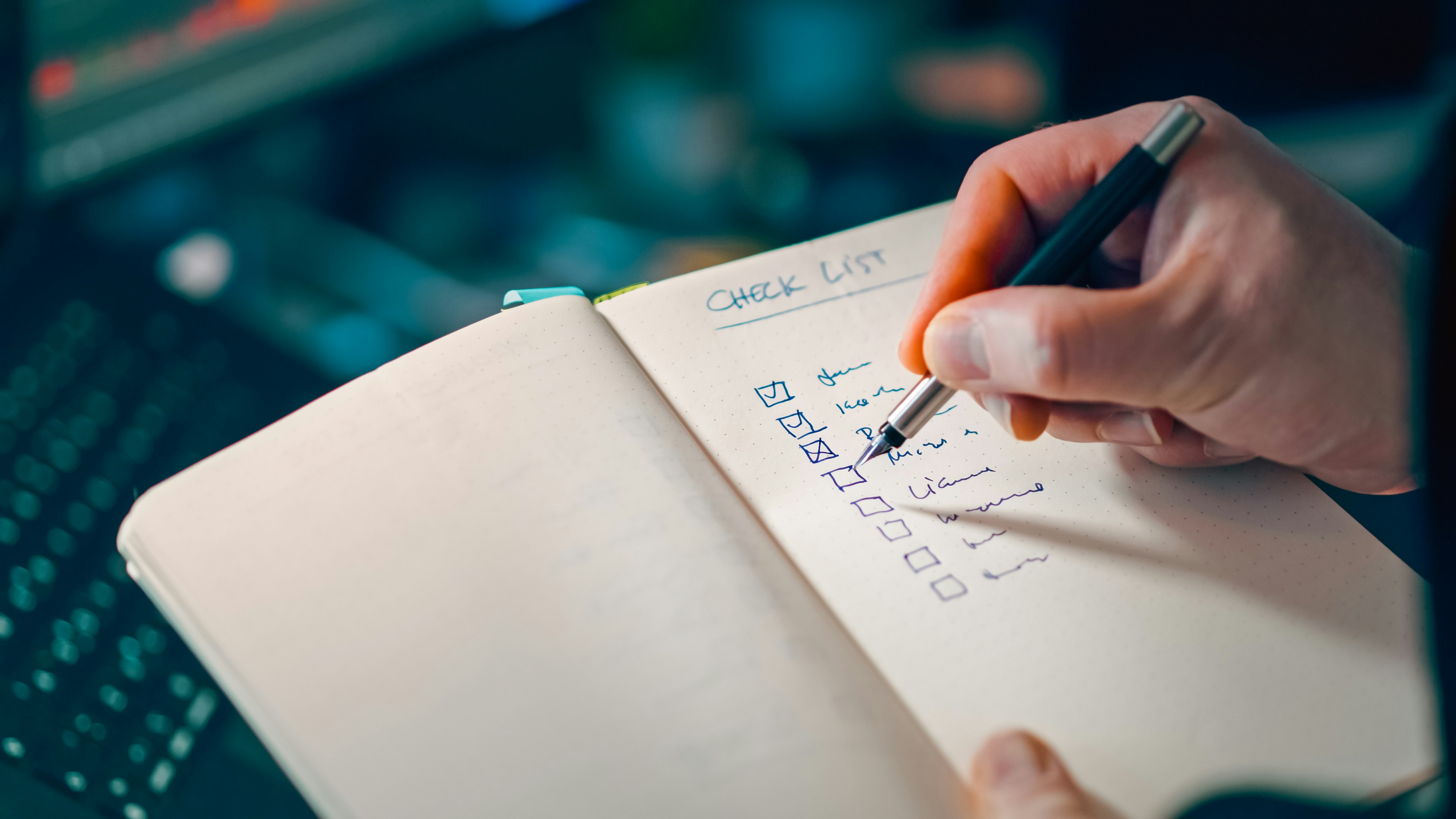 Hand writing a checklist in a notebook