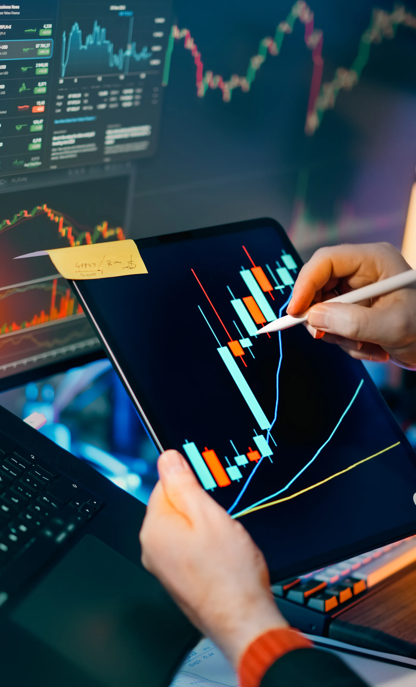 A market analyst reviewing charts on a tablet and monitor