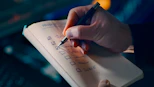 Hand checking off items on a to-do list.