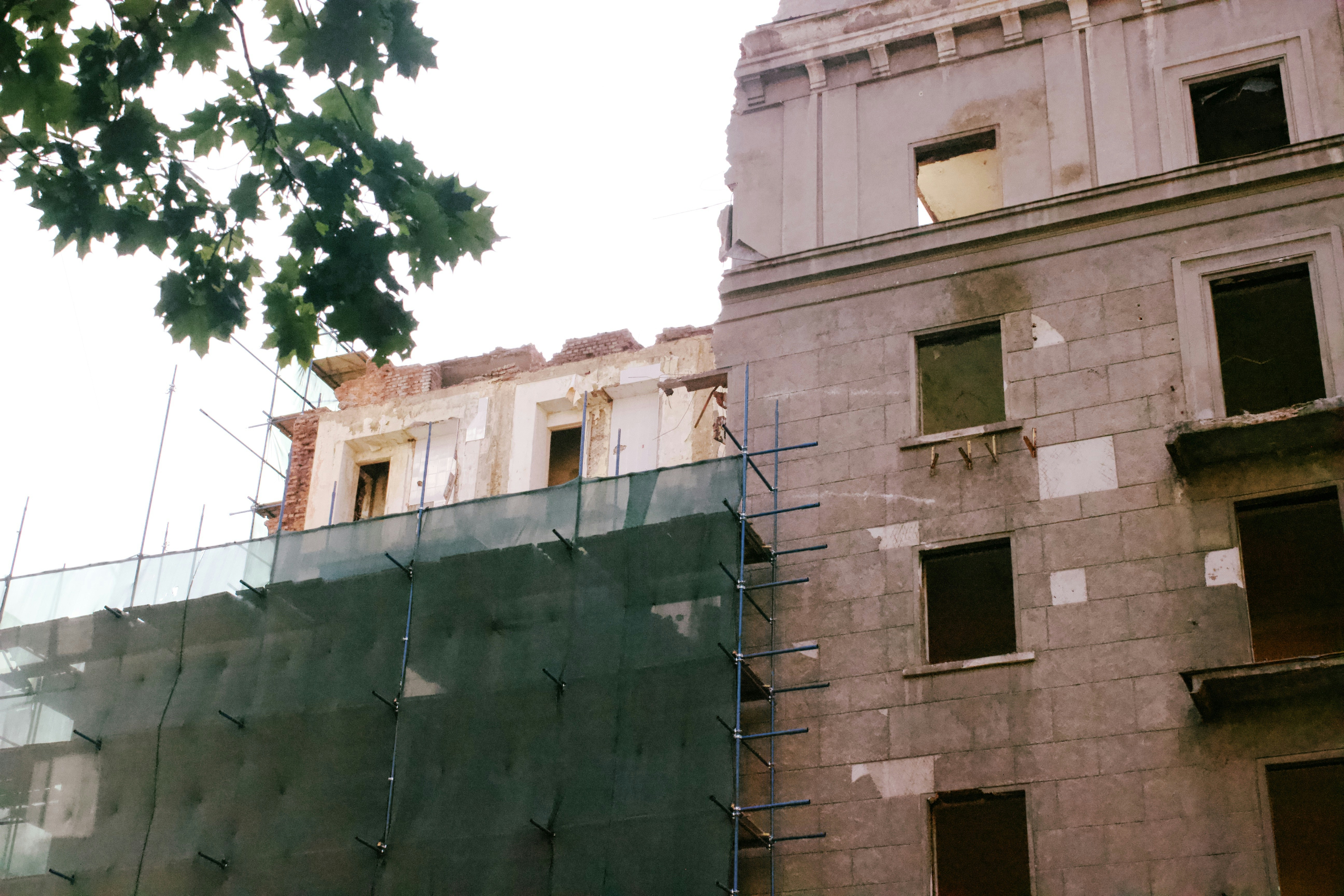 Edifício em construção com andaimes e redes