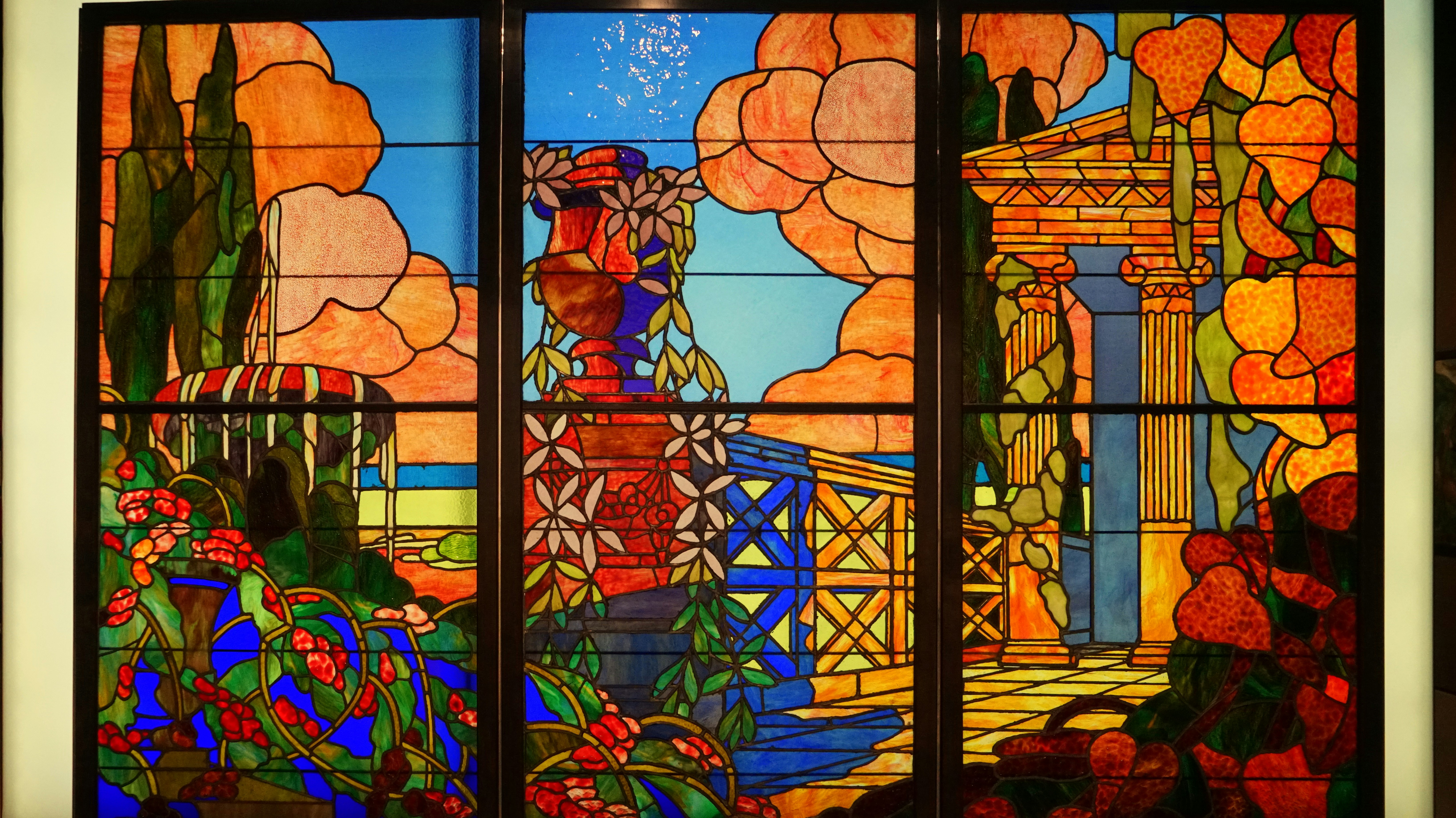 Vitral colorido com elementos arquitetônicos clássicos.