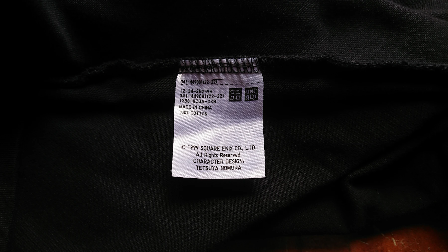 Close-up of a clothing tag with fibre and care information printed on the label
