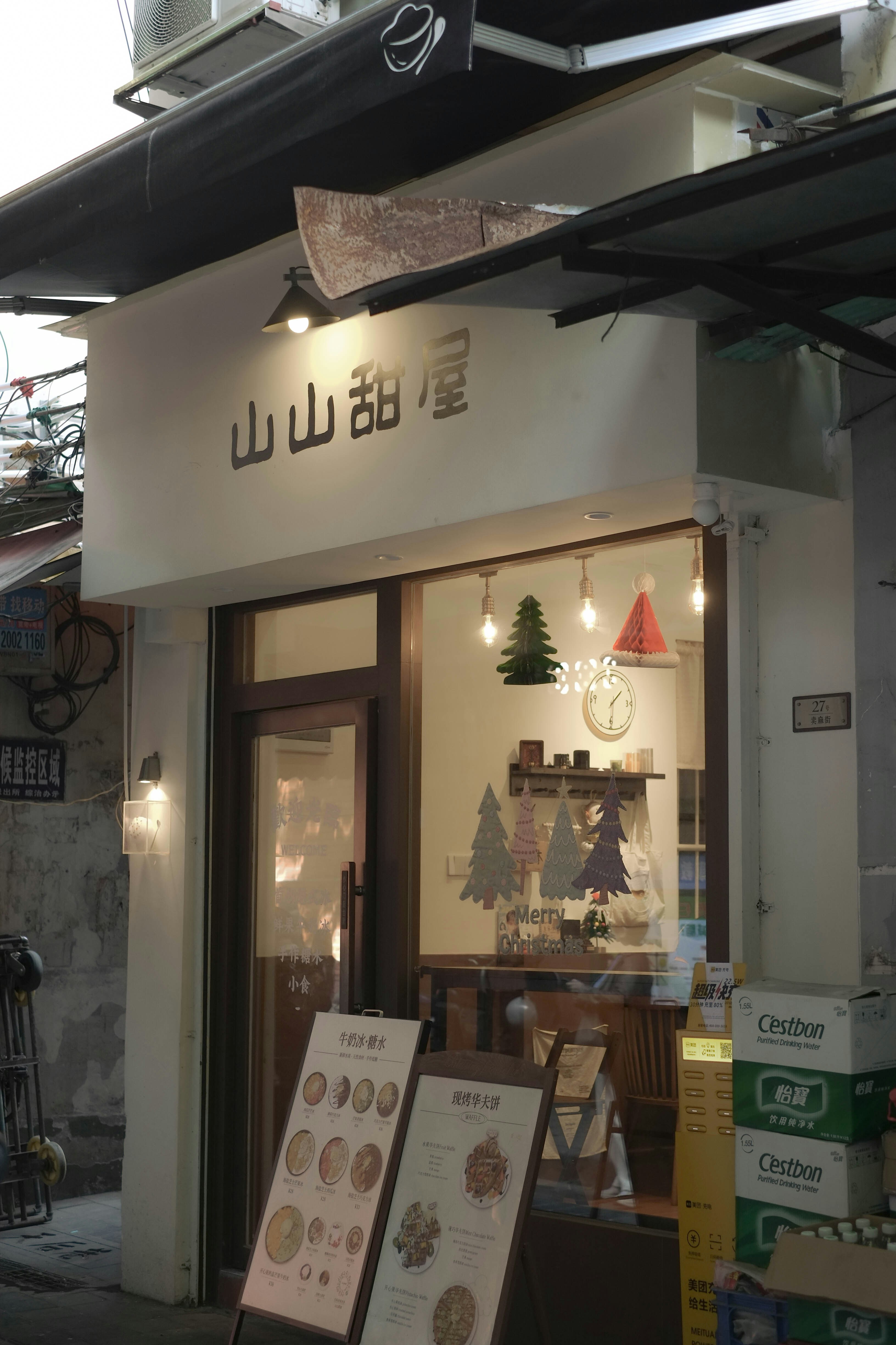 A small bakery storefront with decorative trees in the window