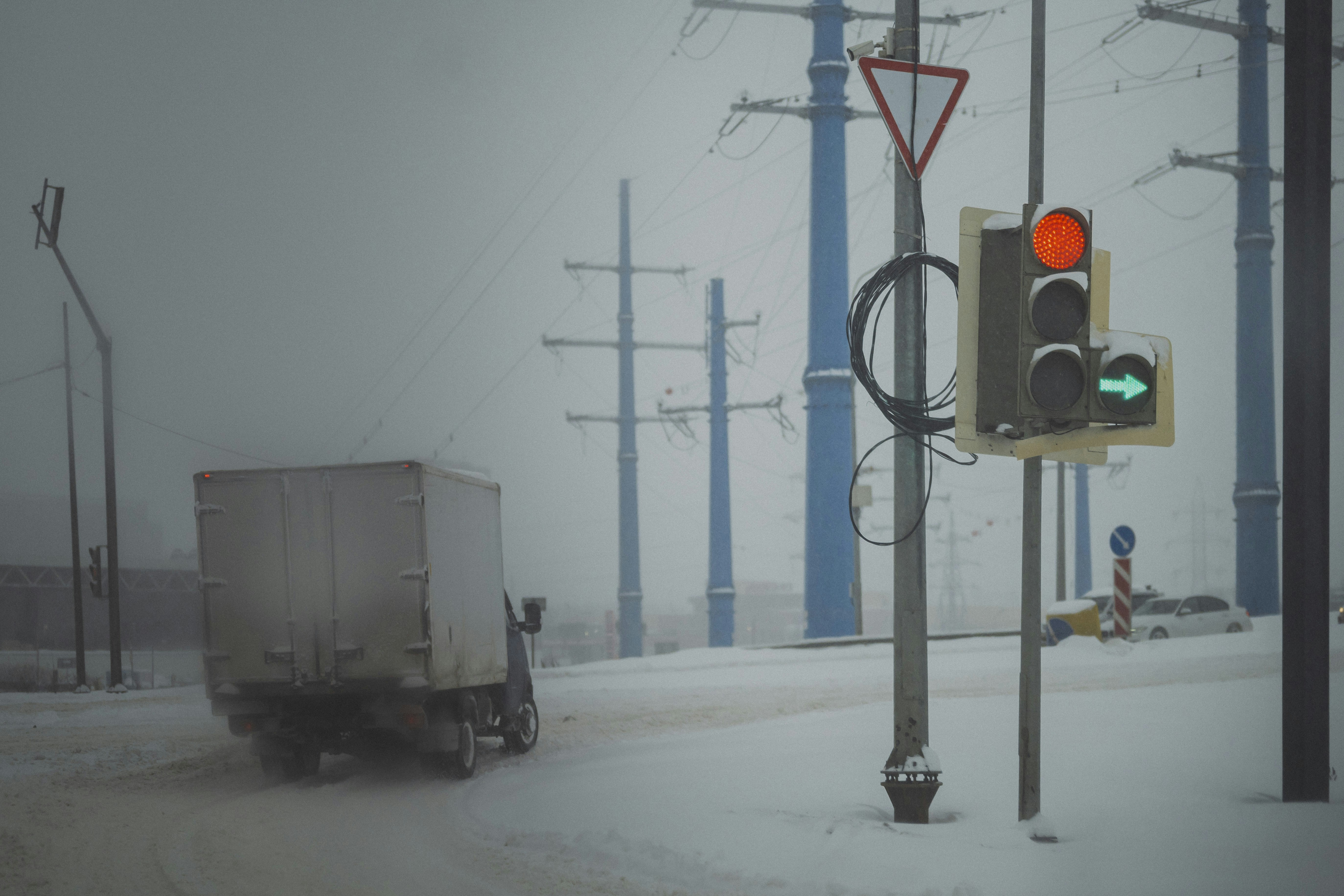 LKW fährt bei verschneitem Wetter mit Ampeln.