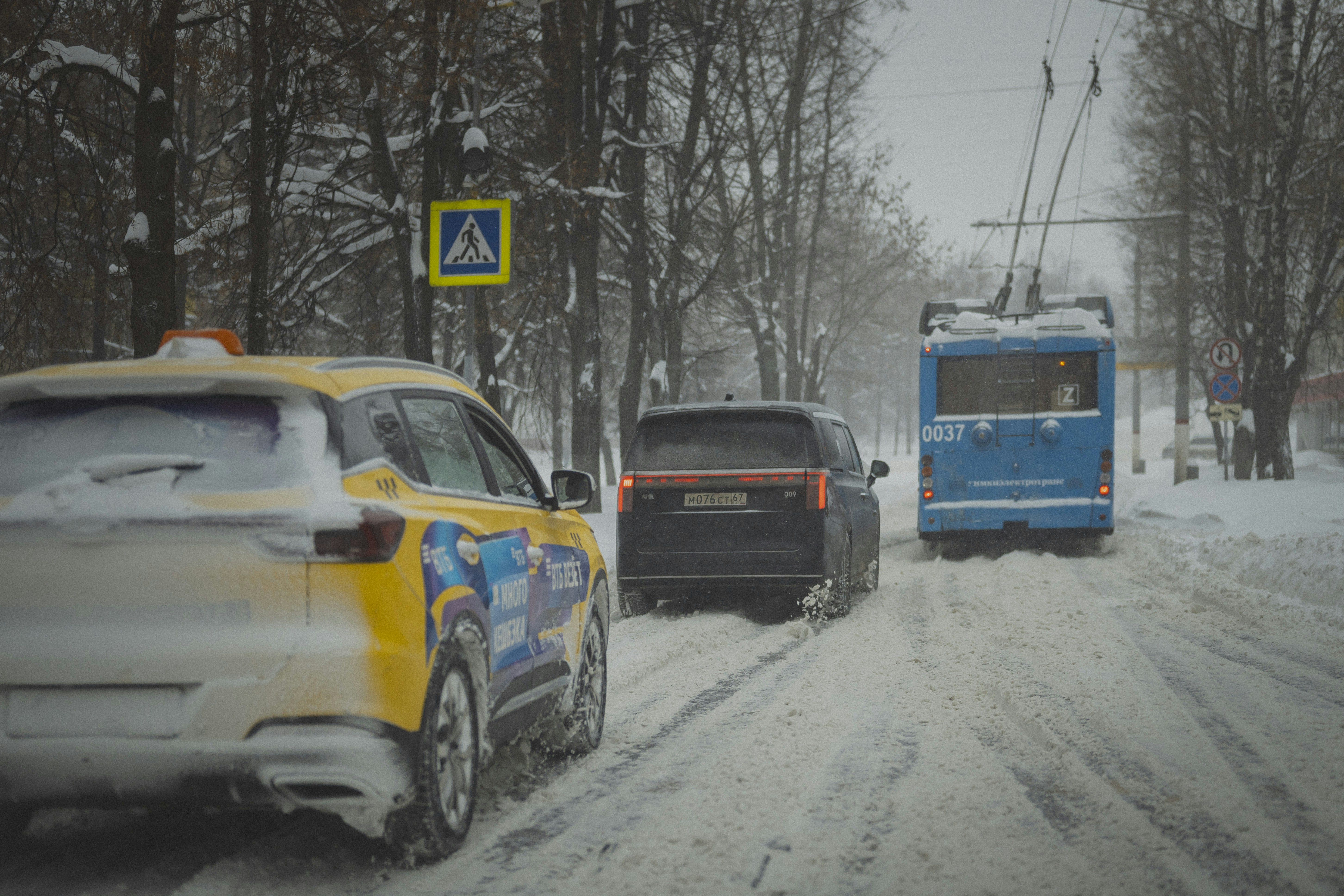 Fahrzeuge, die im Winter auf einer verschneiten Straße fahren.