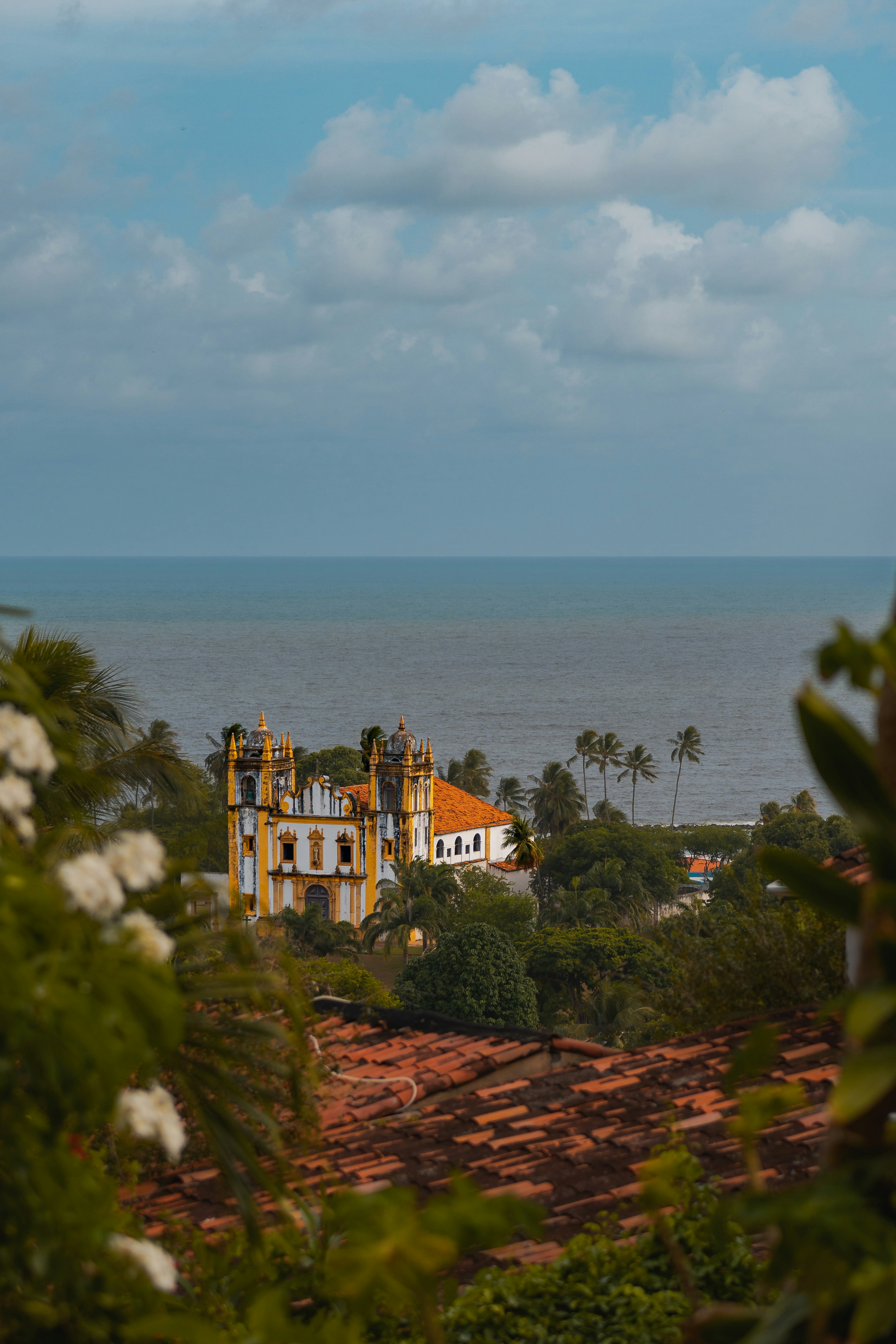 Historic church overlooking the ocean surrounded by trees.