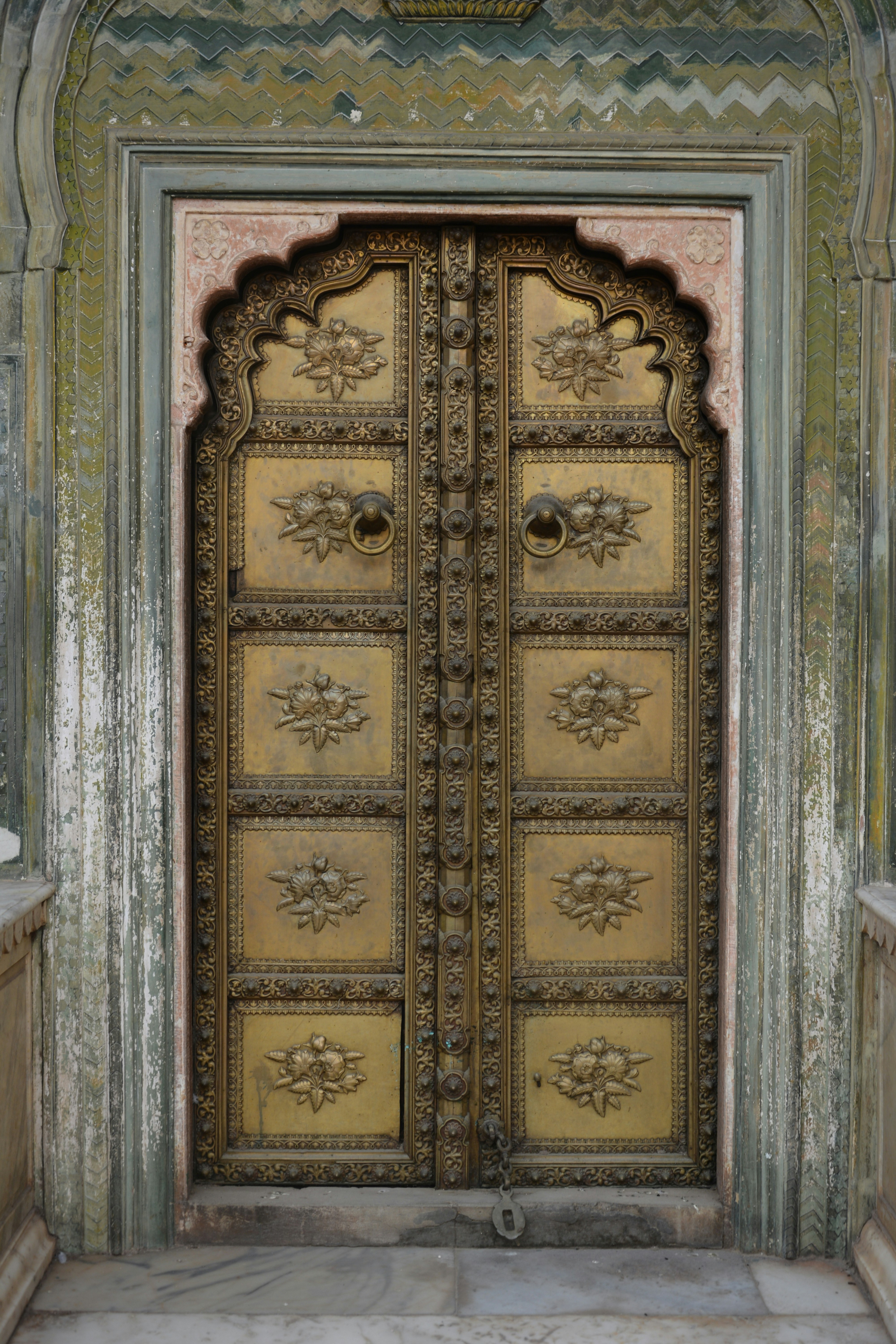 Ornate brass double doors with intricate floral carvings.