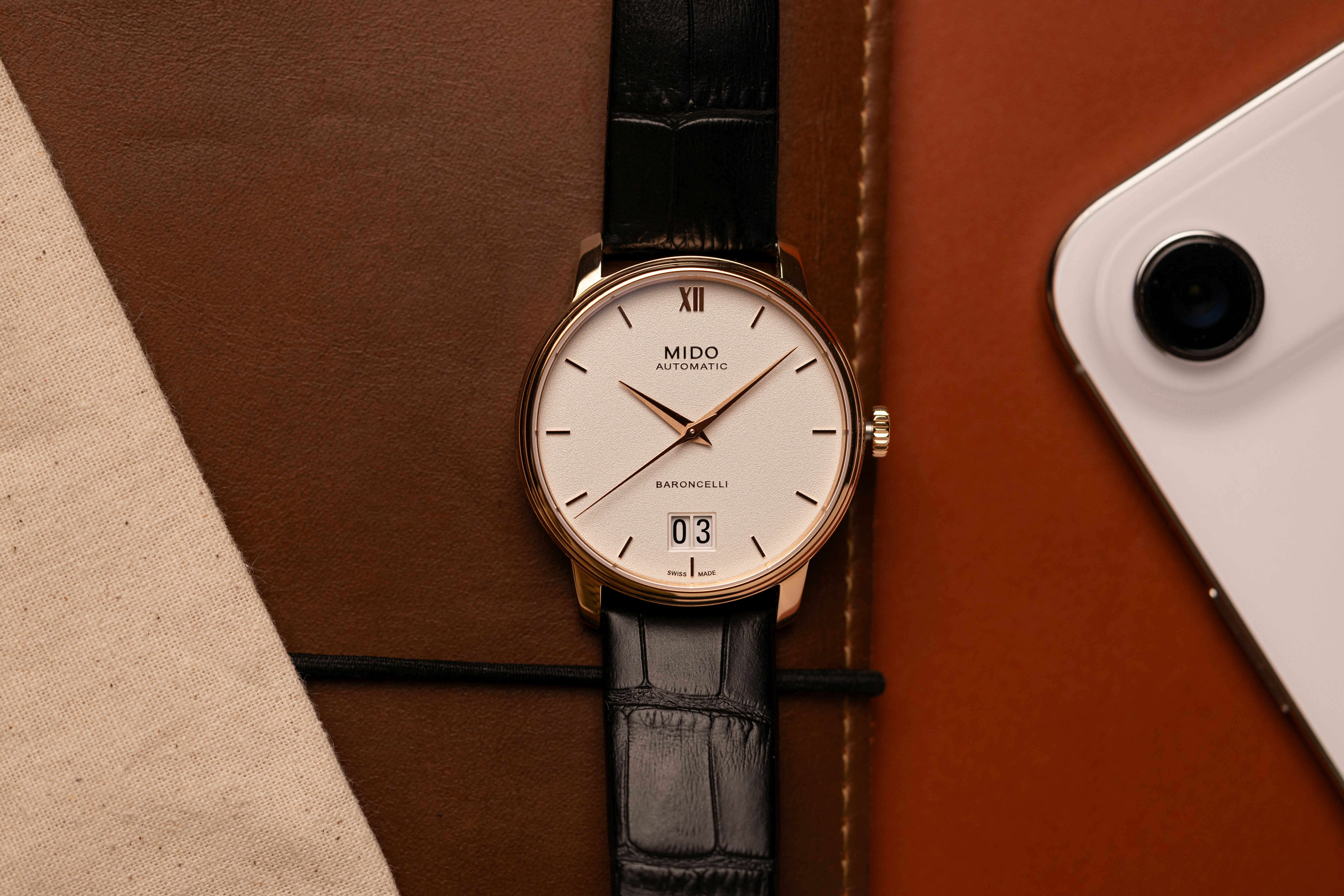 A classic wristwatch with a white face and black strap.