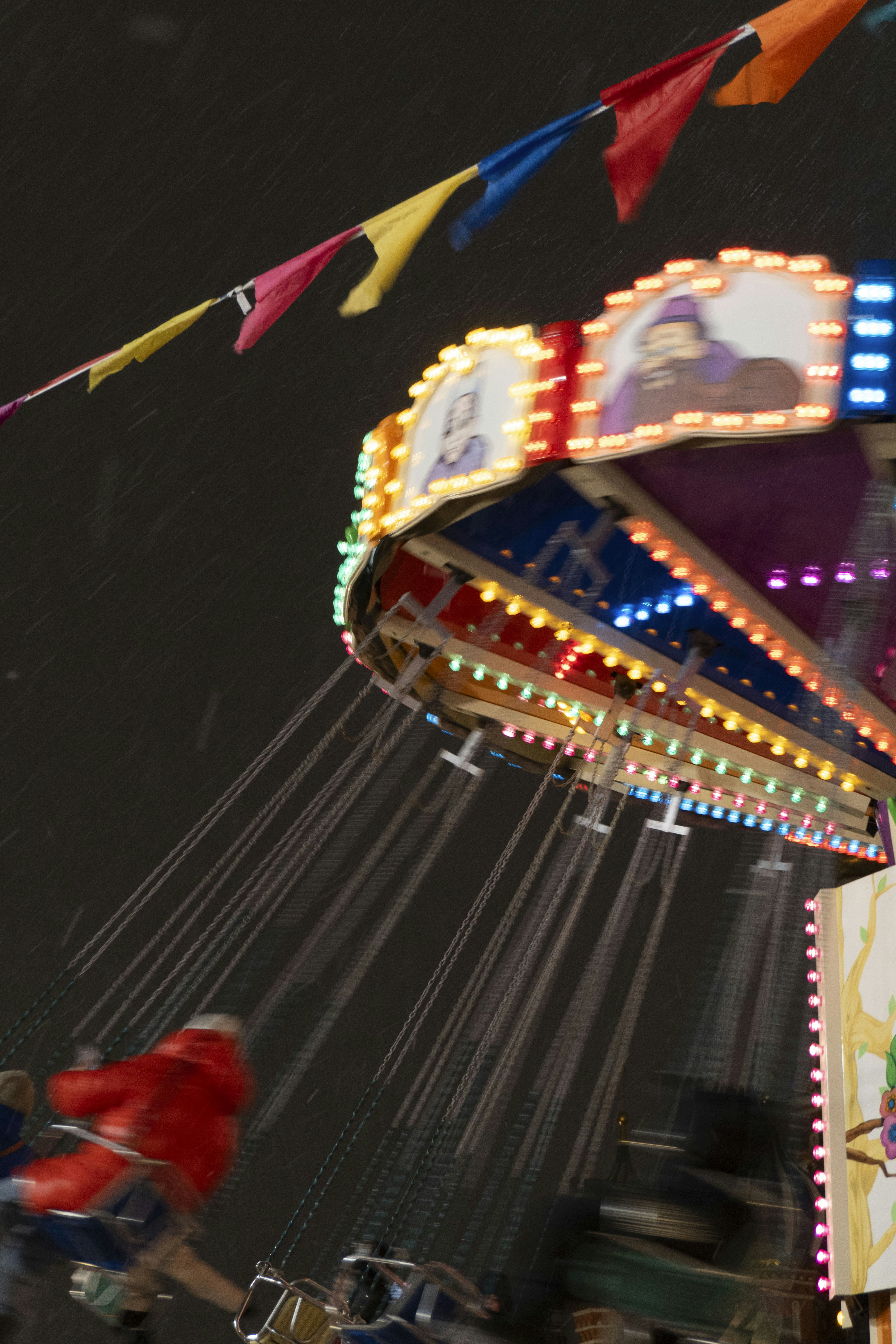 Swinging amusement ride with colorful lights at night