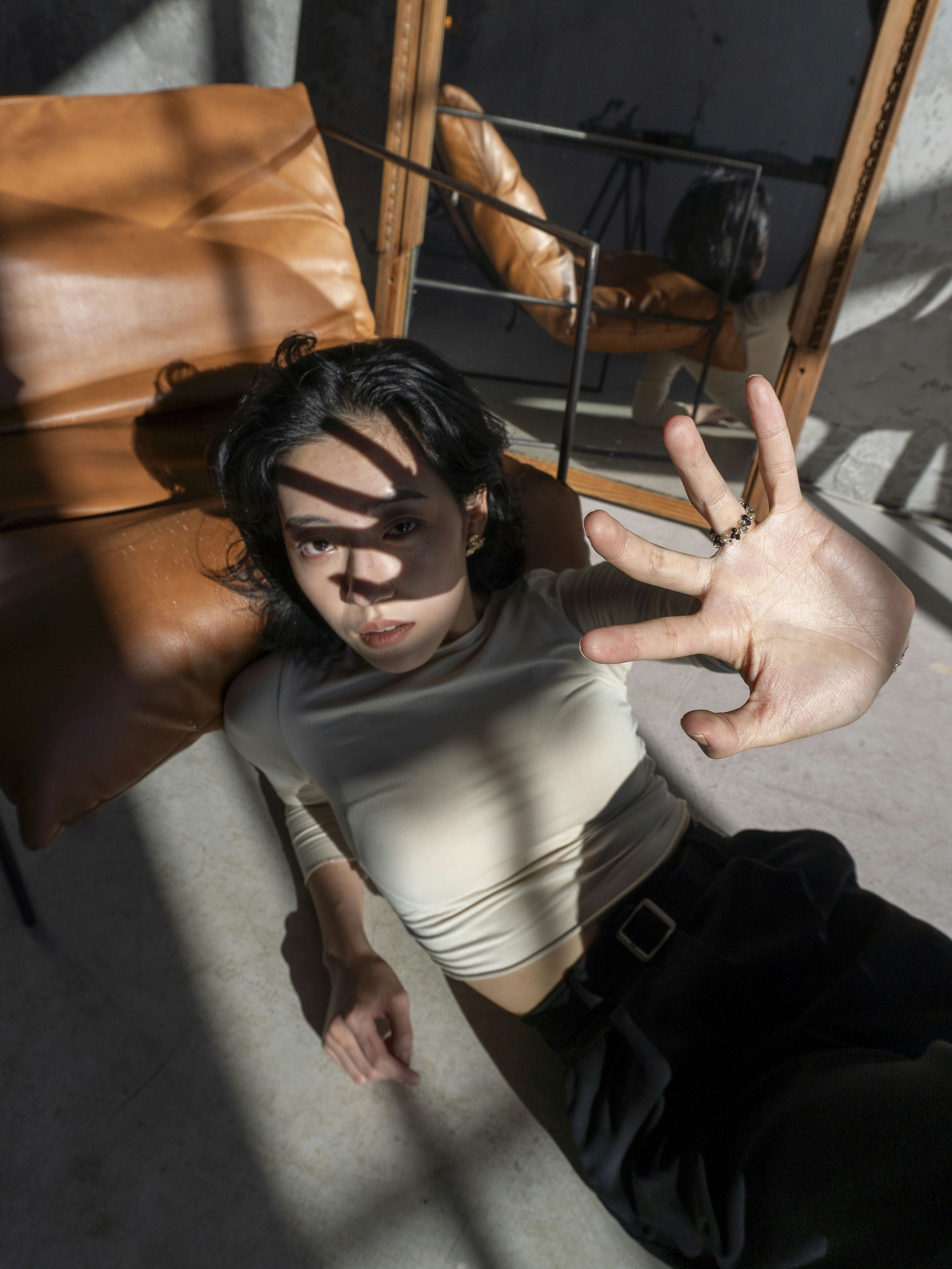 Young person lying on floor with sunlight casting shadows
