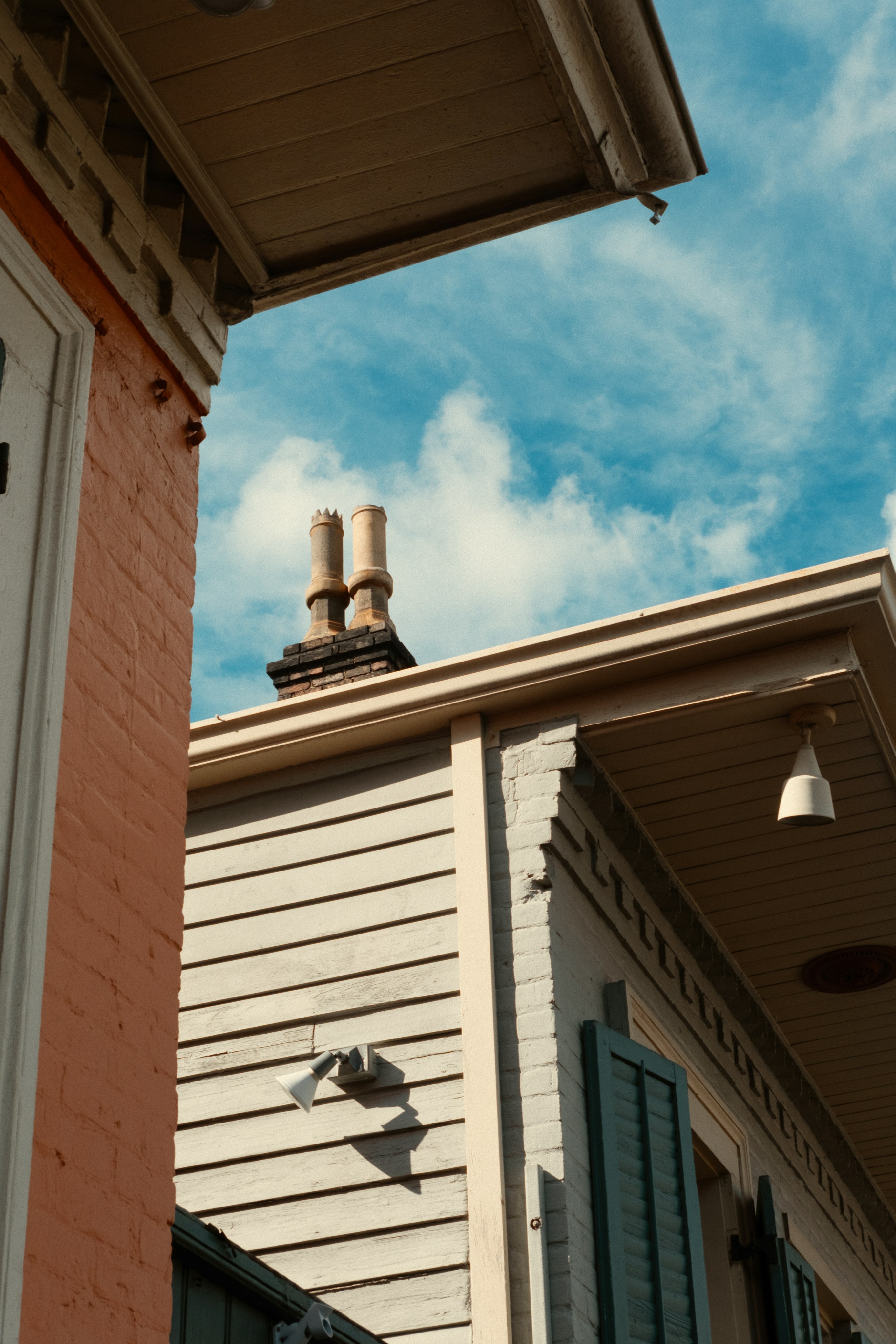 Two buildings against a cloudy blue sky