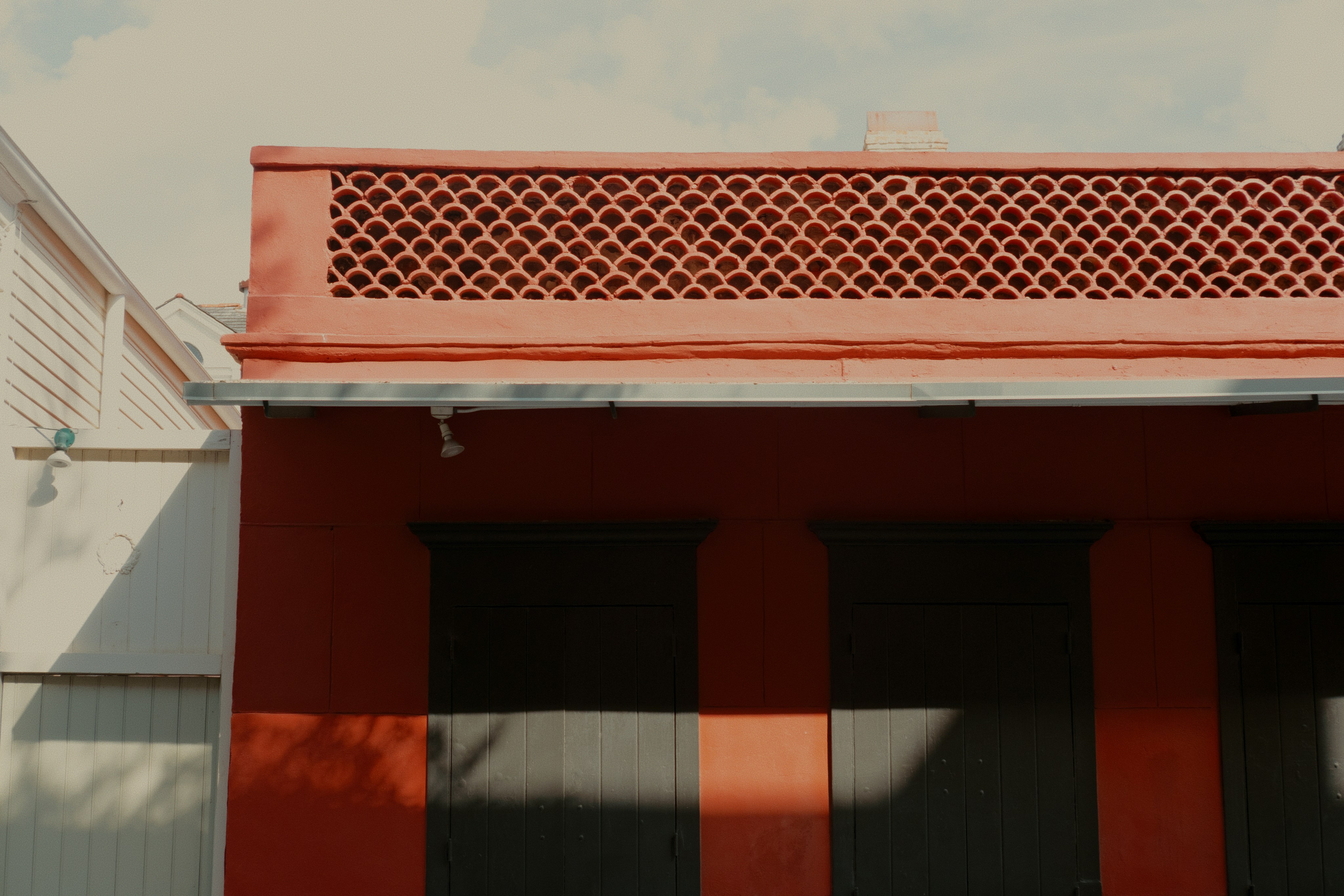 Red building facade with decorative patterned vent