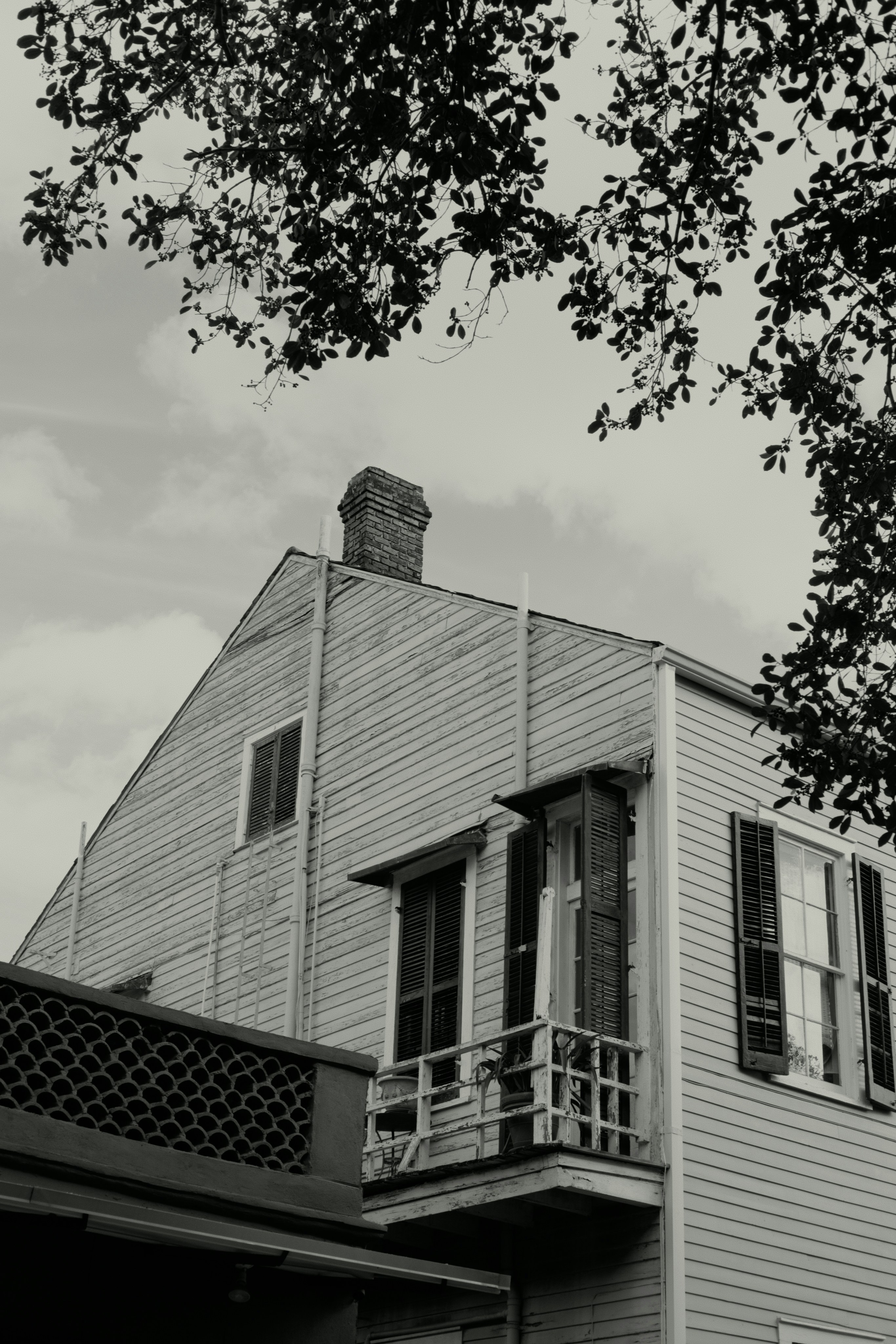 Historic wooden house with shutters and balcony.
