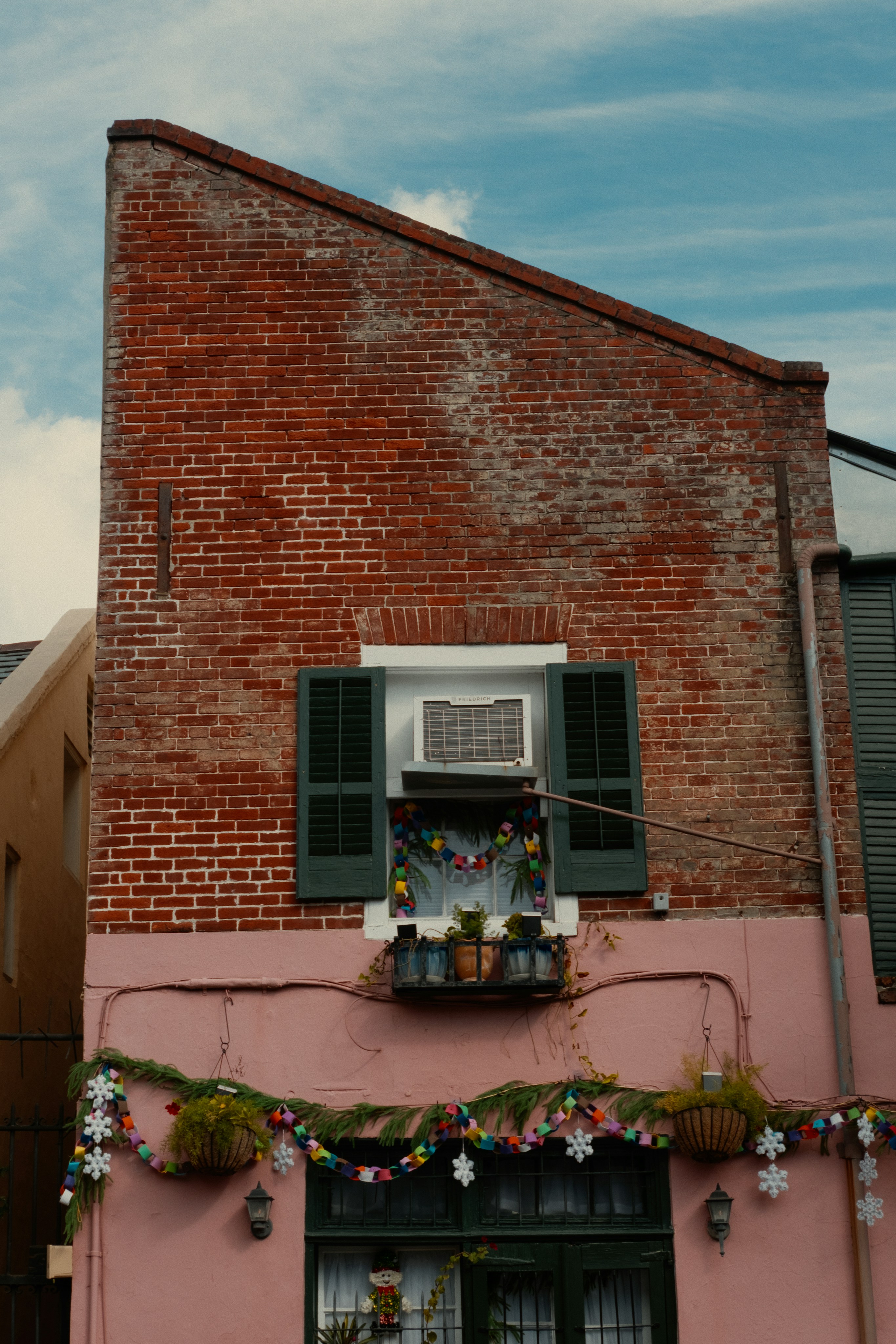 Pink building with red brick facade and festive decorations.