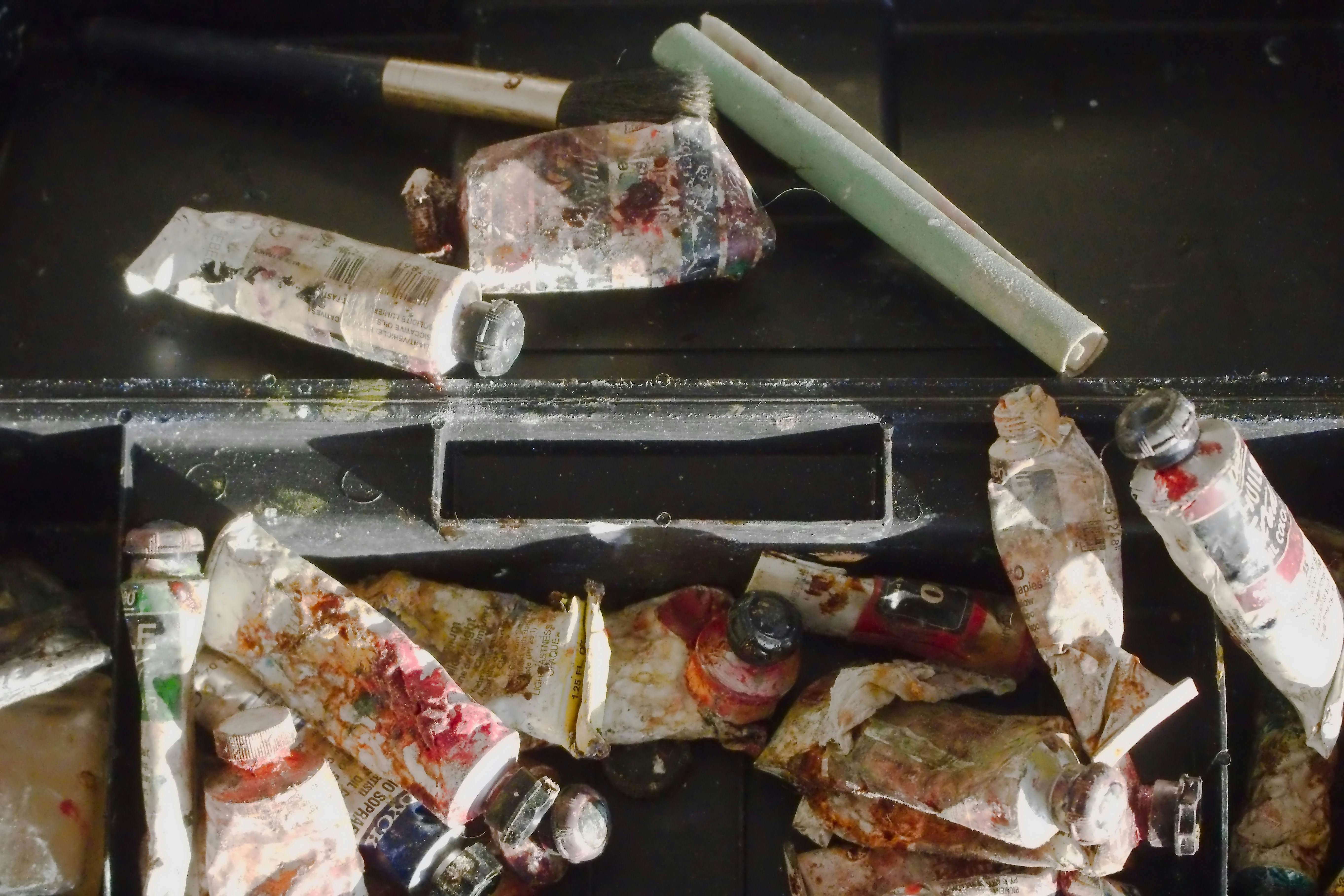 Tubes of paint and a brush in a box