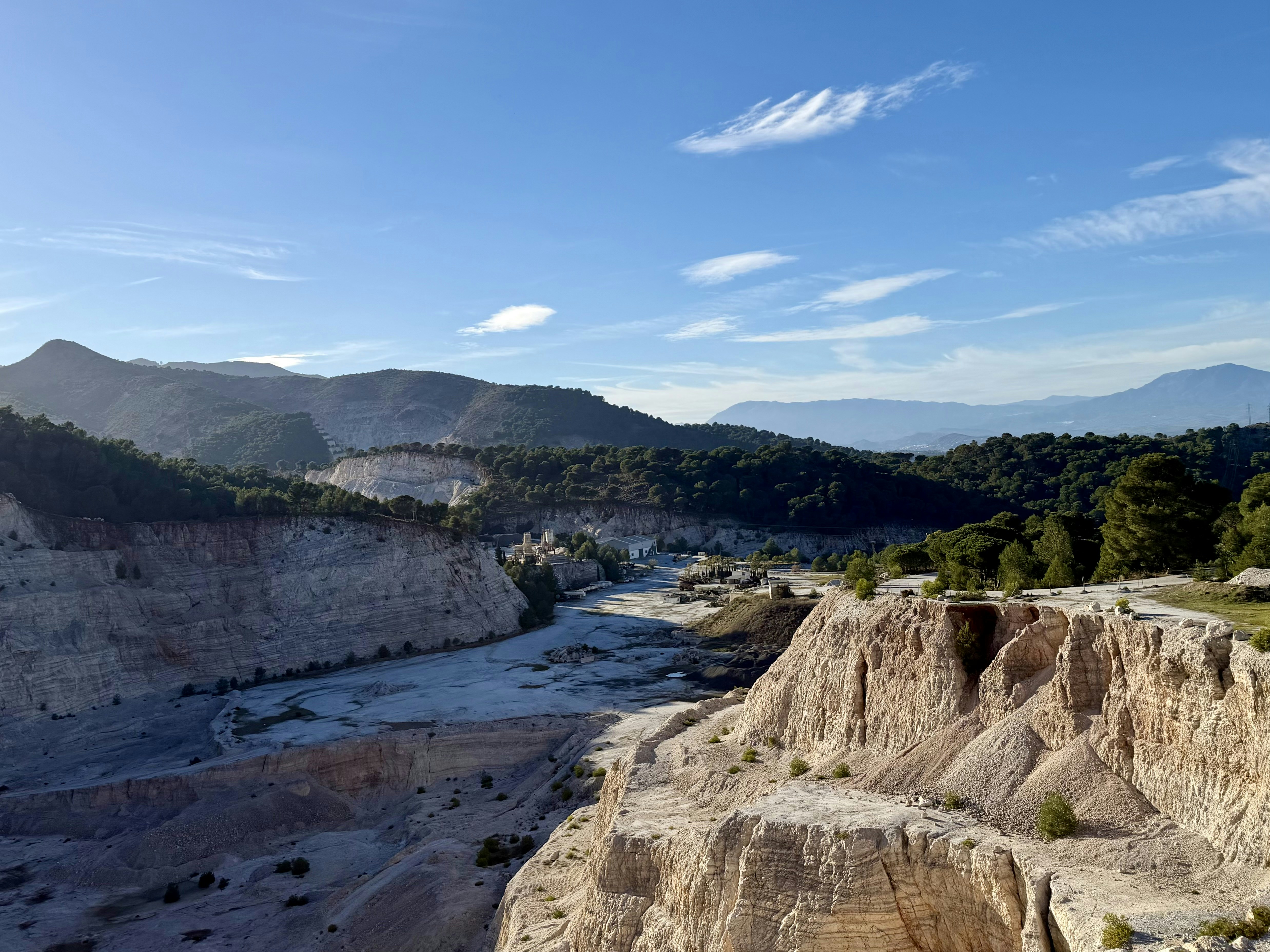 Expansive quarry landscape with rolling hills and blue sky