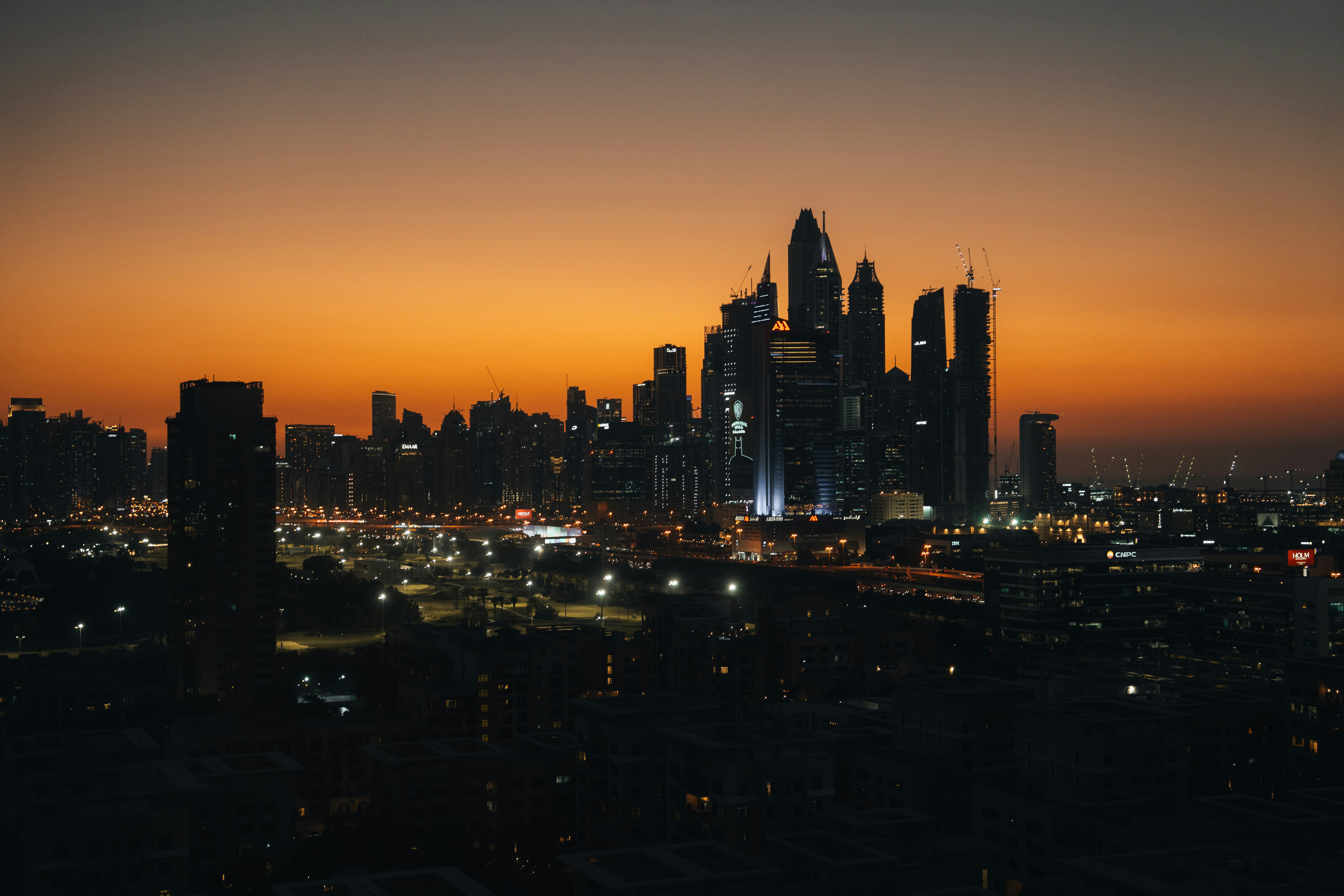 City skyline at dusk with warm orange sky.