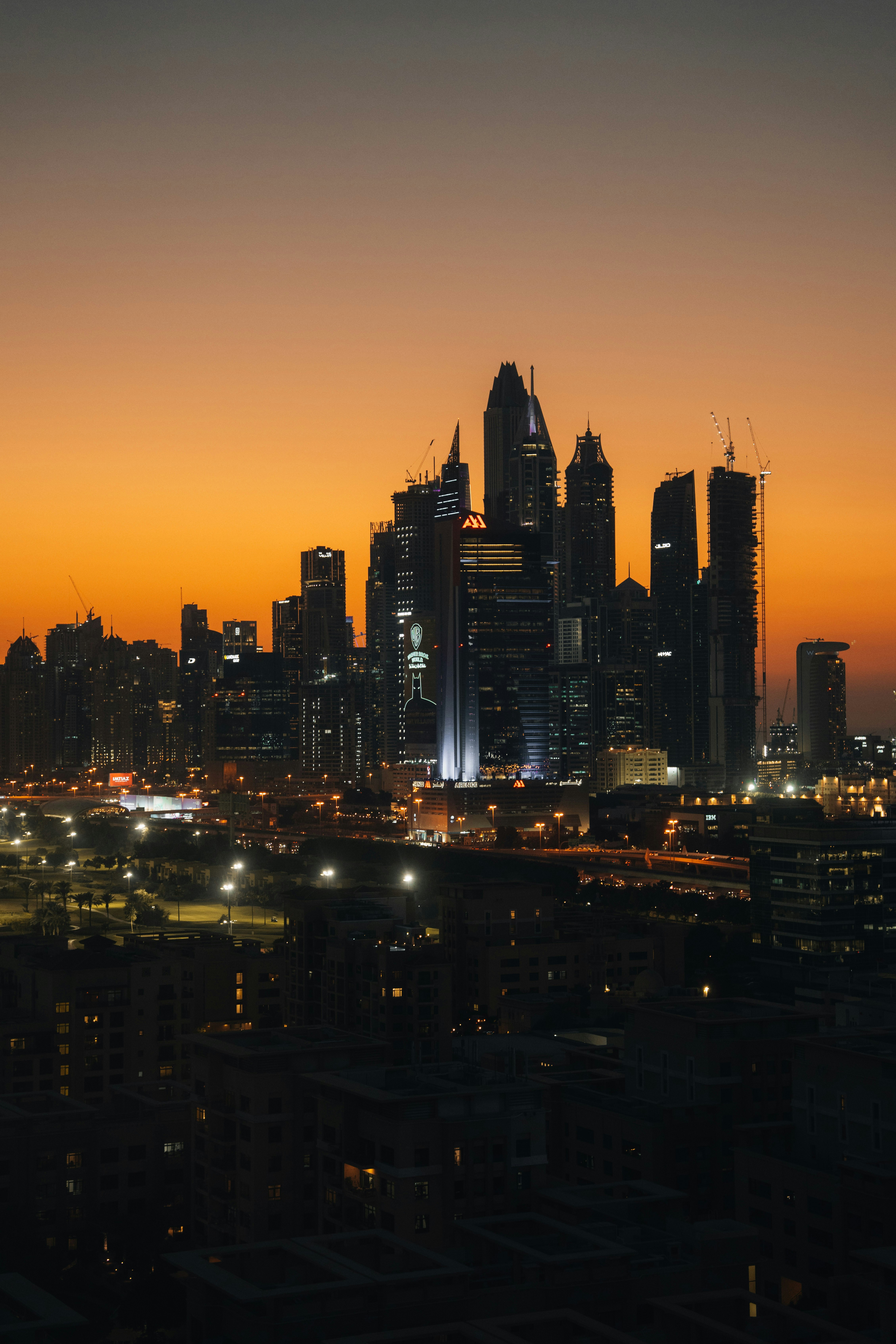 City skyline illuminated against an orange sunset sky