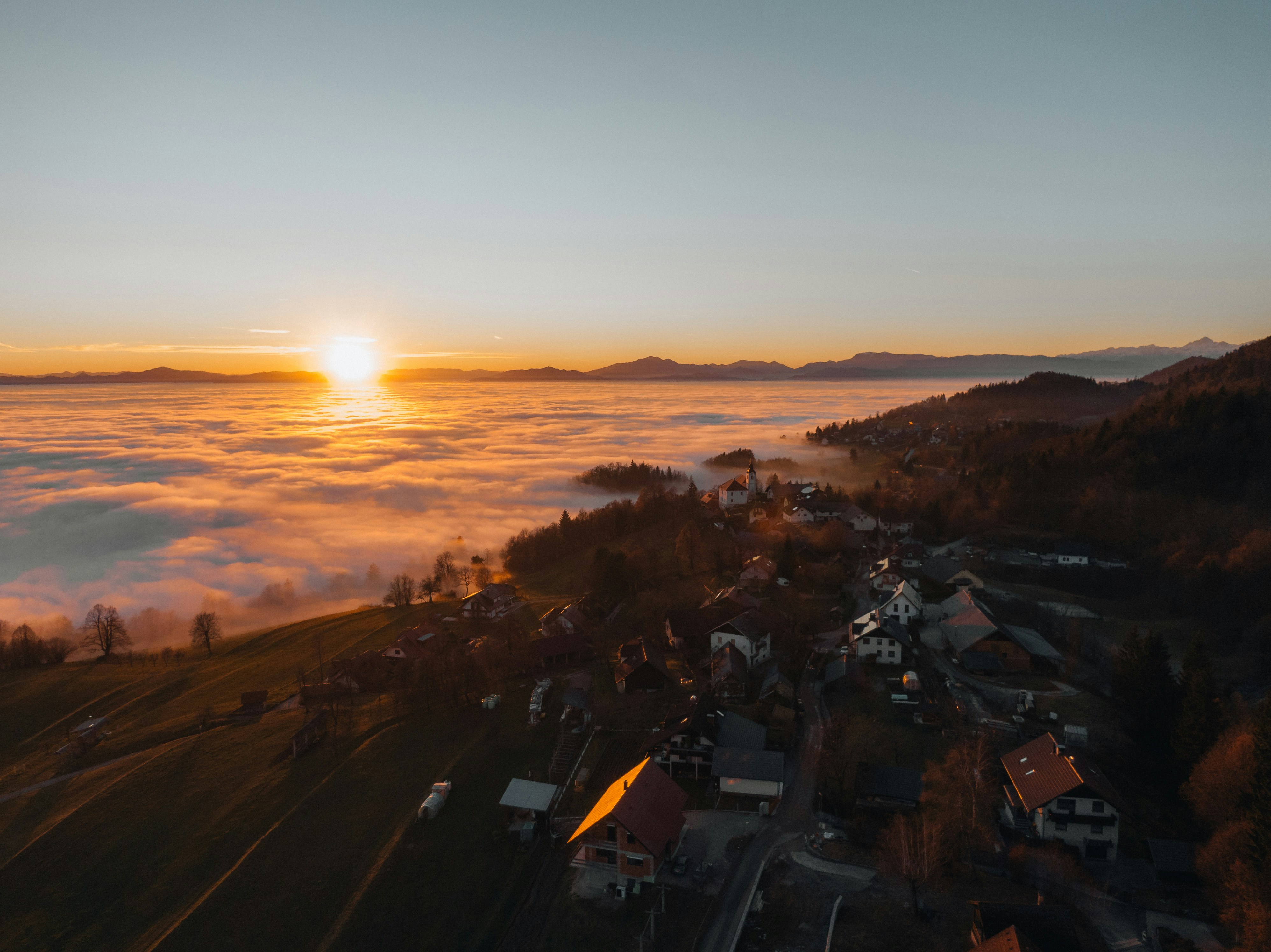 Sunrise over a foggy valley with a village.