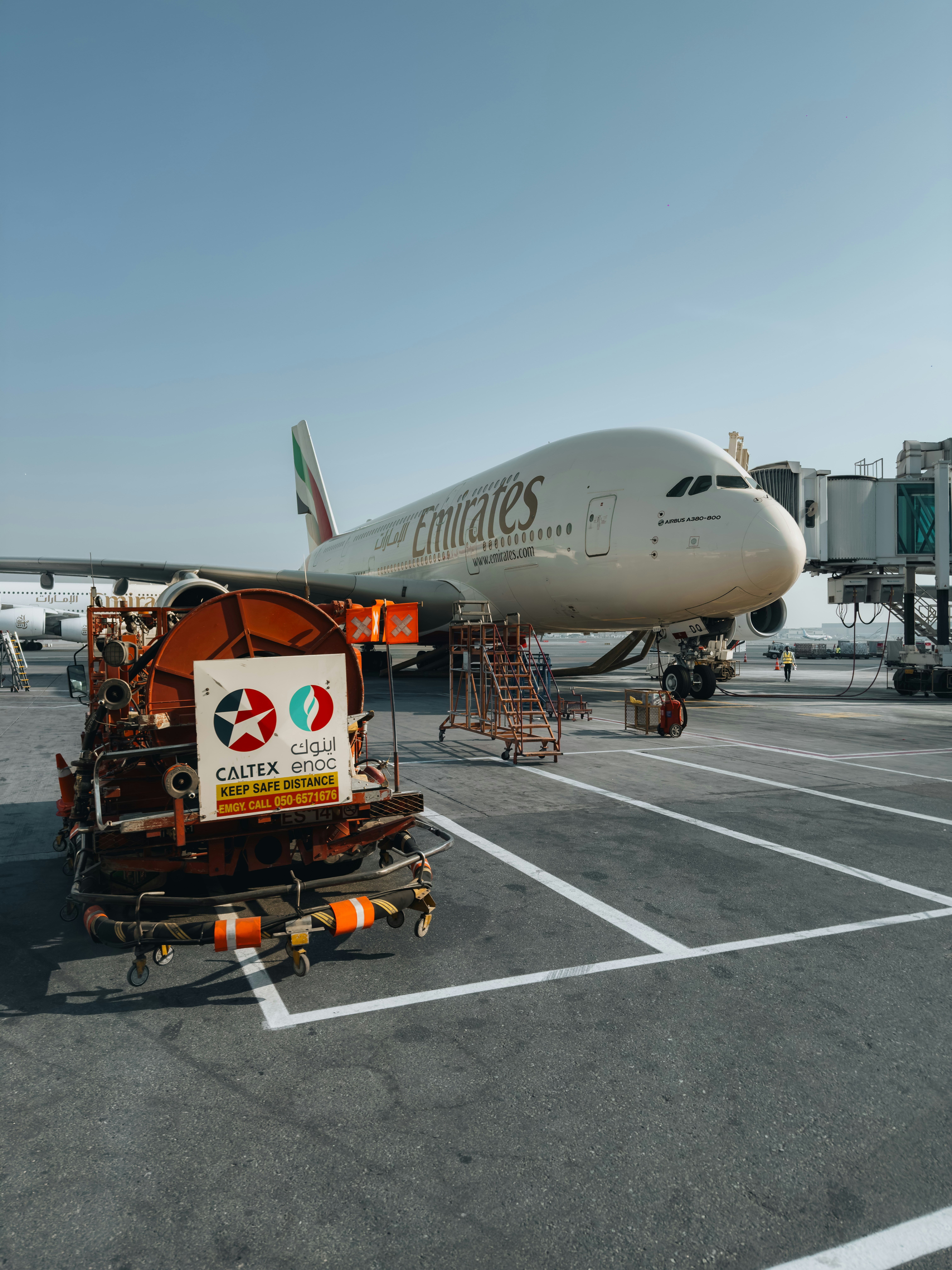 Emirates airplane at the gate with jet bridge attached.