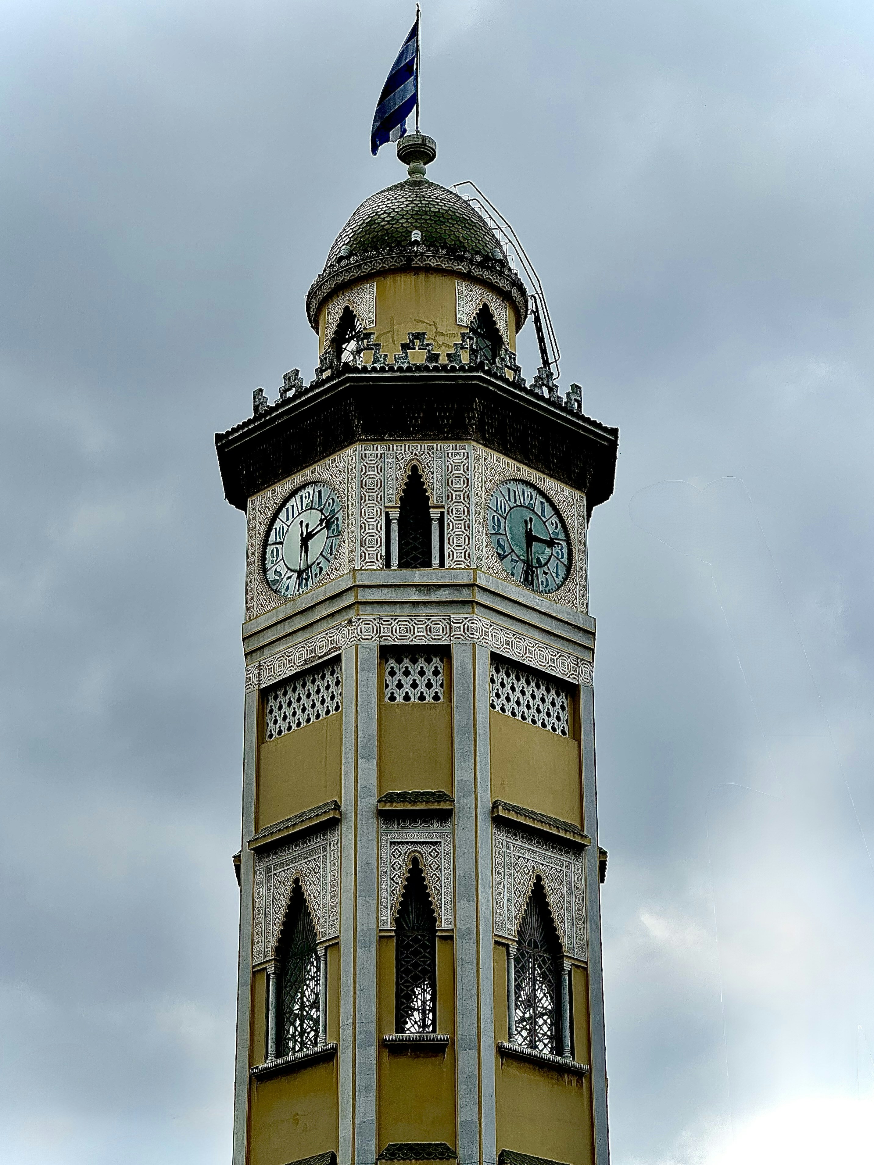 Une haute tour d’horloge avec un drapeau au sommet