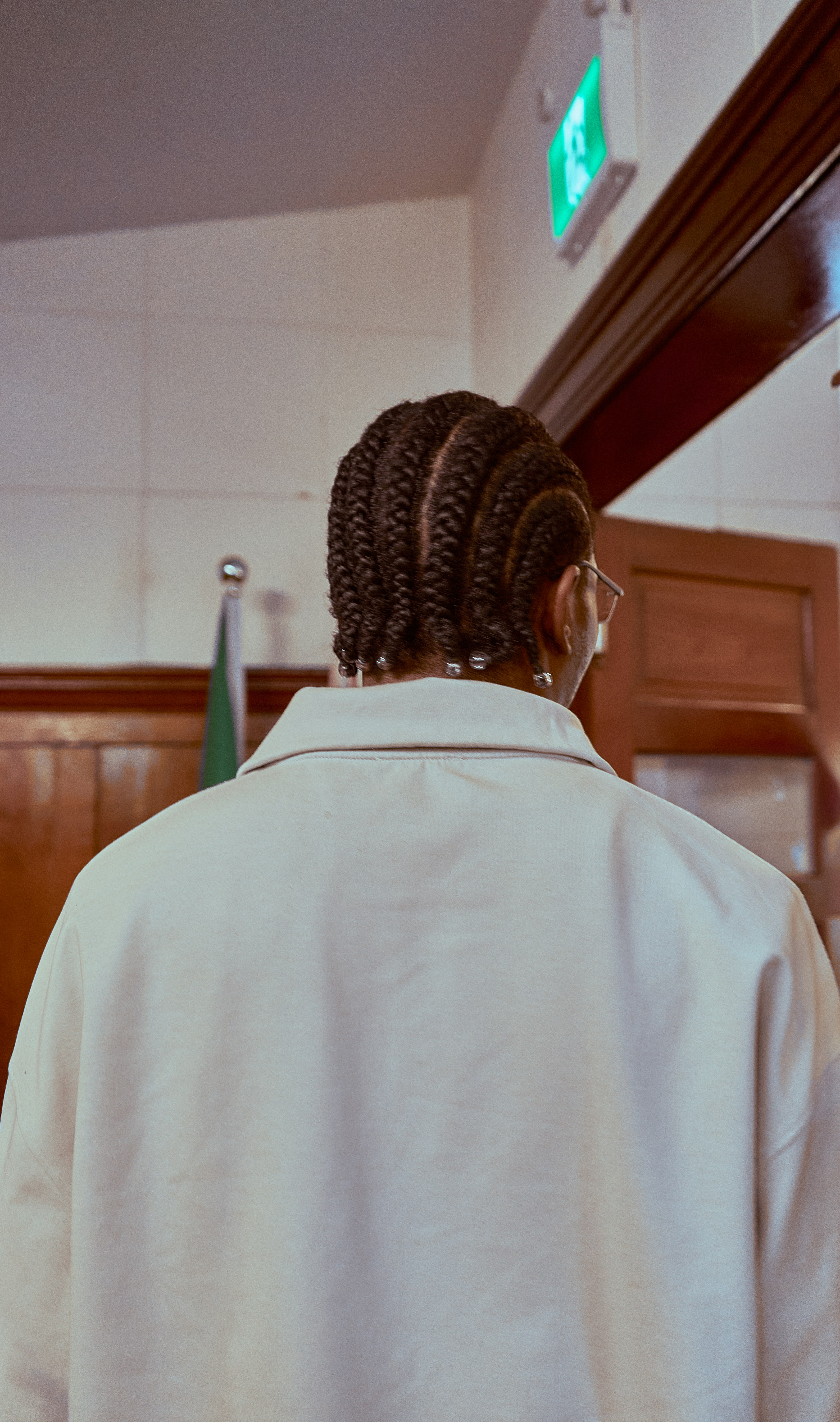 Person with braided hair wearing a light jacket