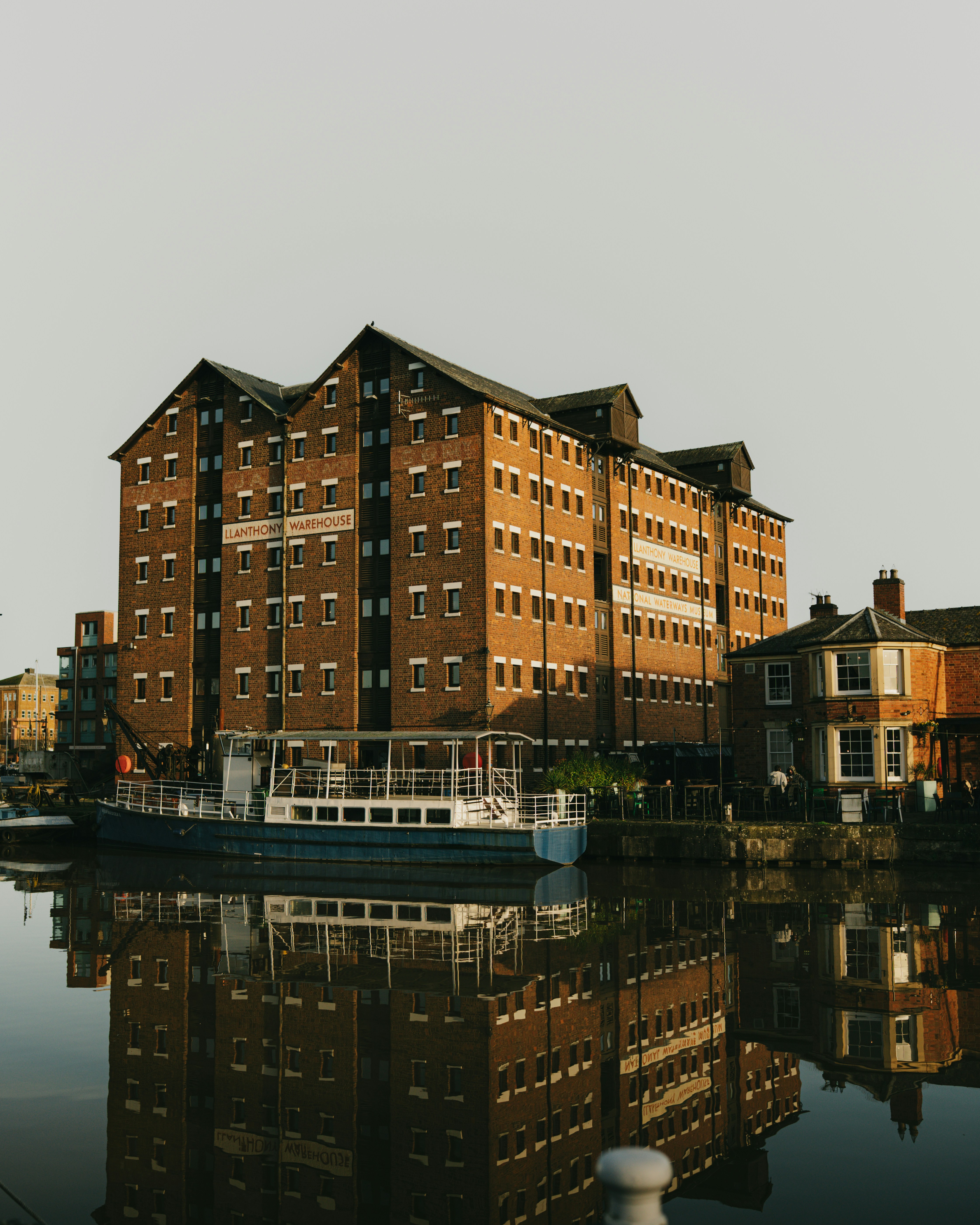 Large brick building reflected in calm water
