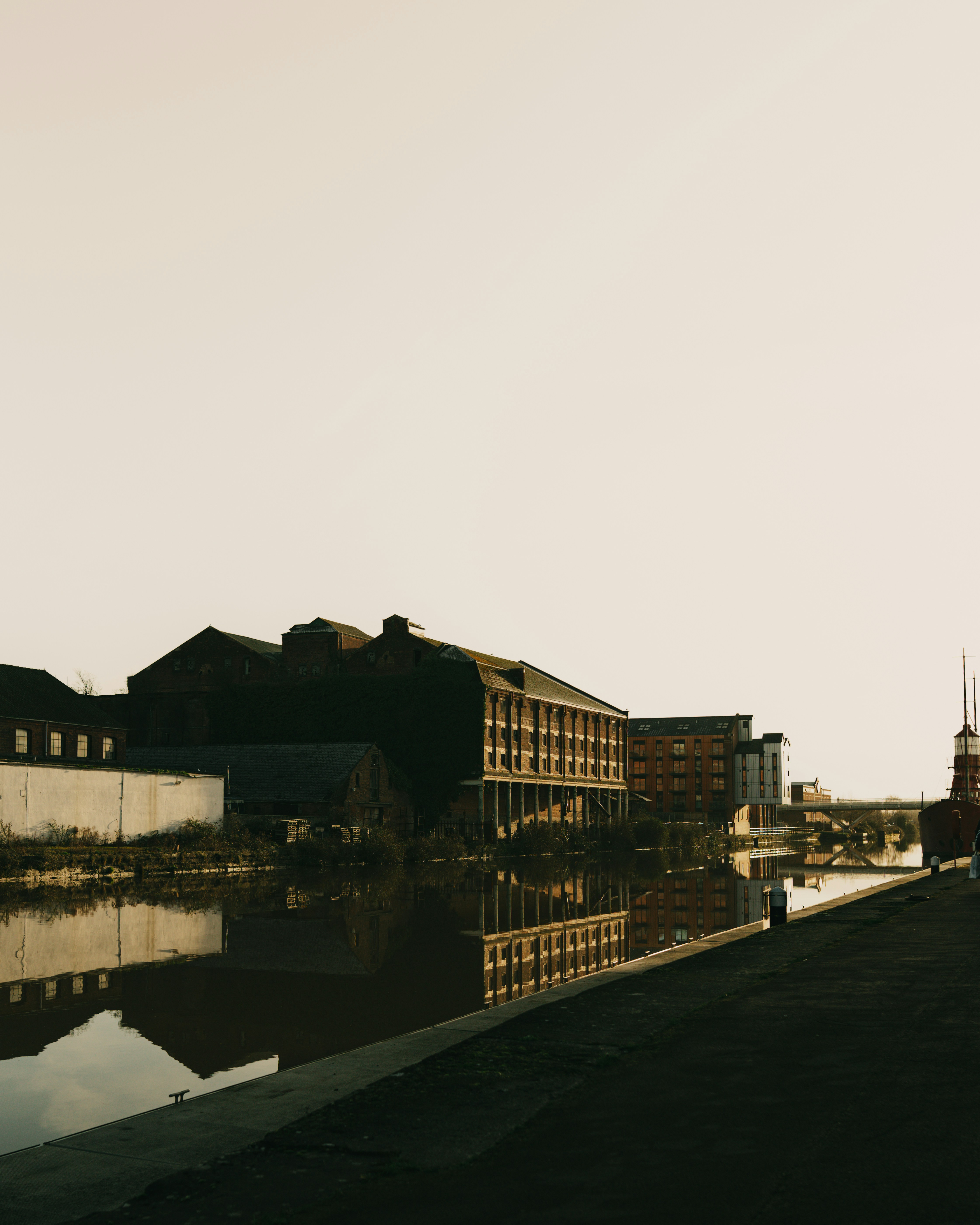 Buildings reflected in a calm canal at dusk.