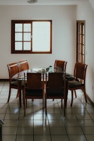A wooden dining table with chairs in a room