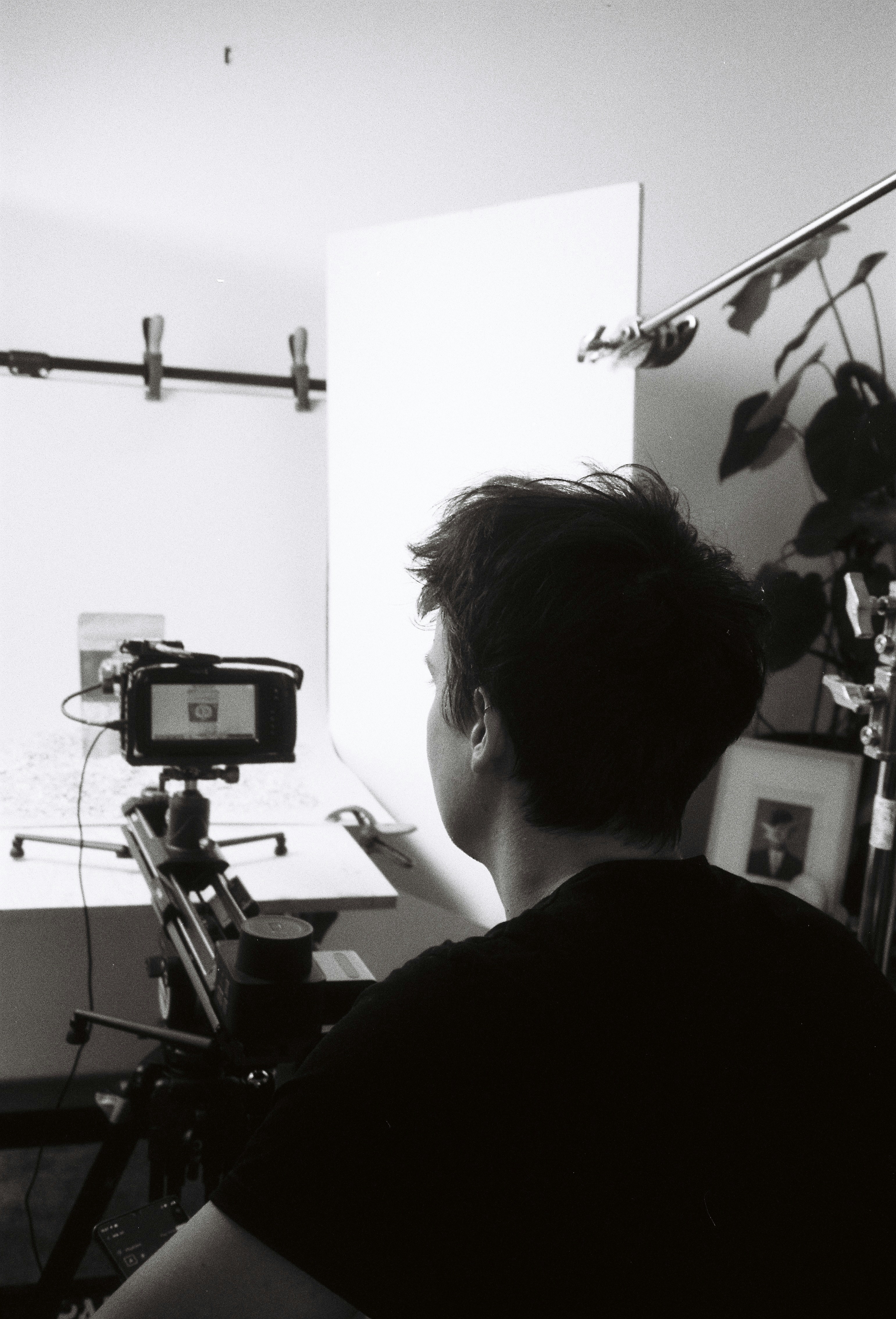 Person filming with camera on tripod in studio