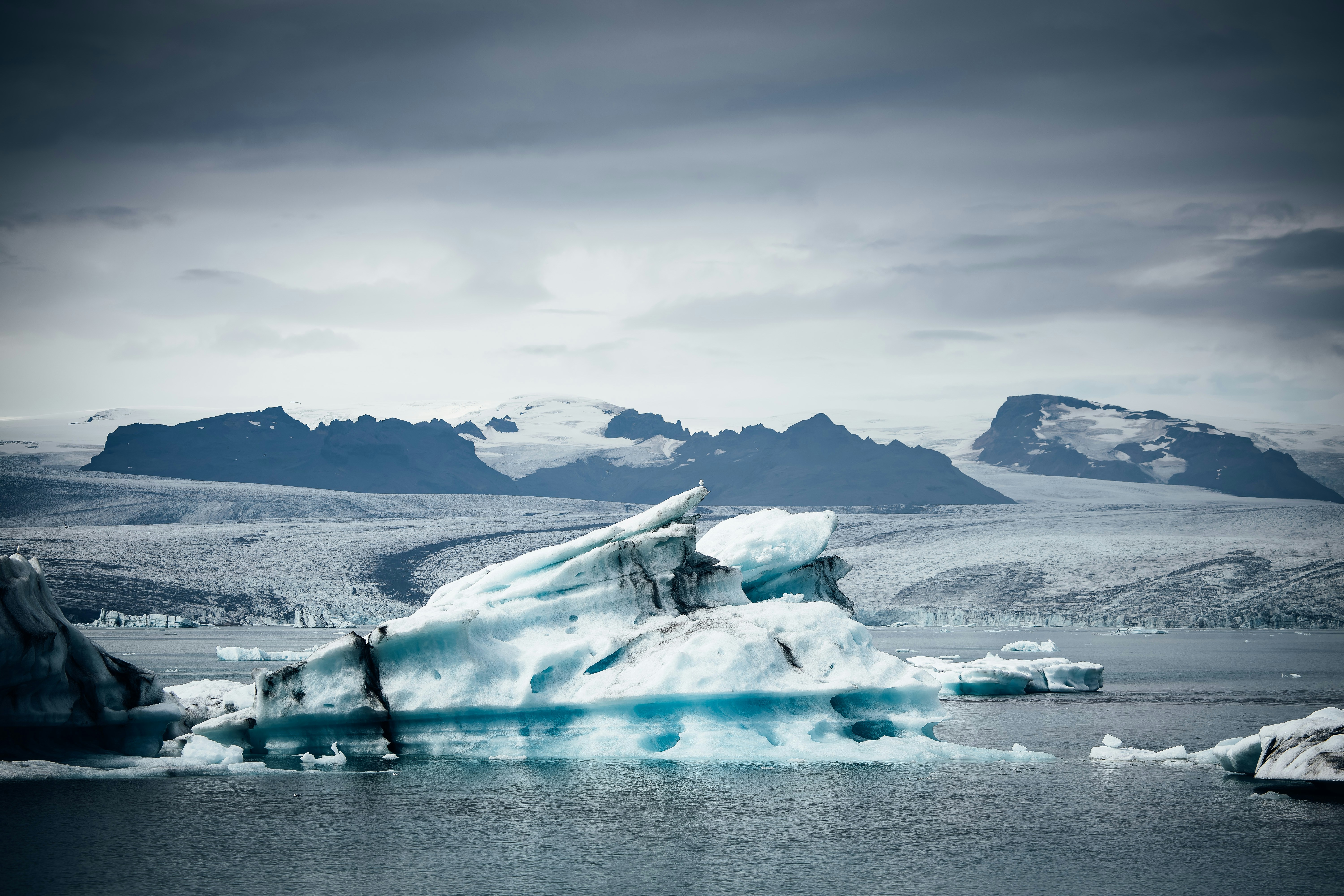 Icebergs floating in a glacial lagoon with mountains behind