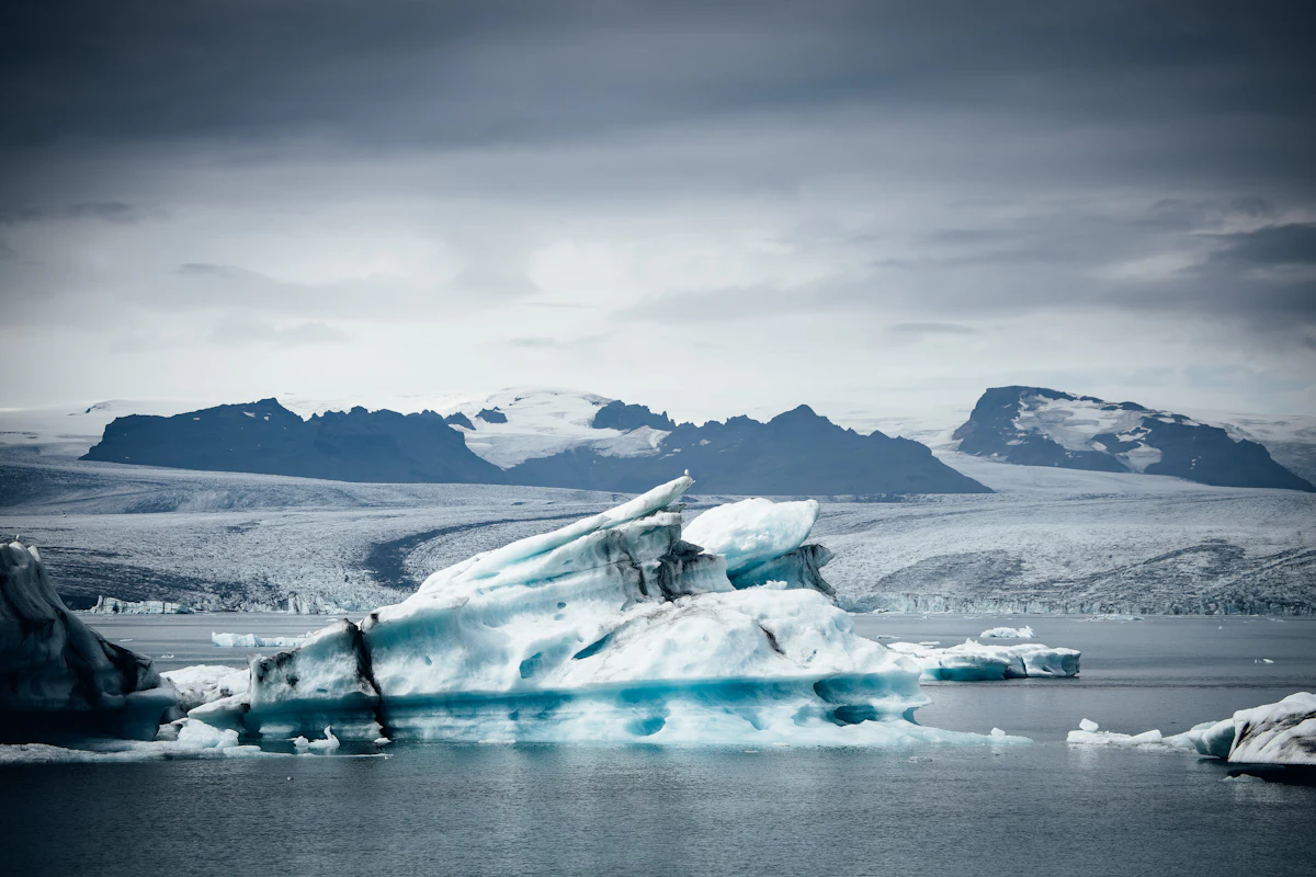 Icebergs floating in a glacial lagoon with mountains behind