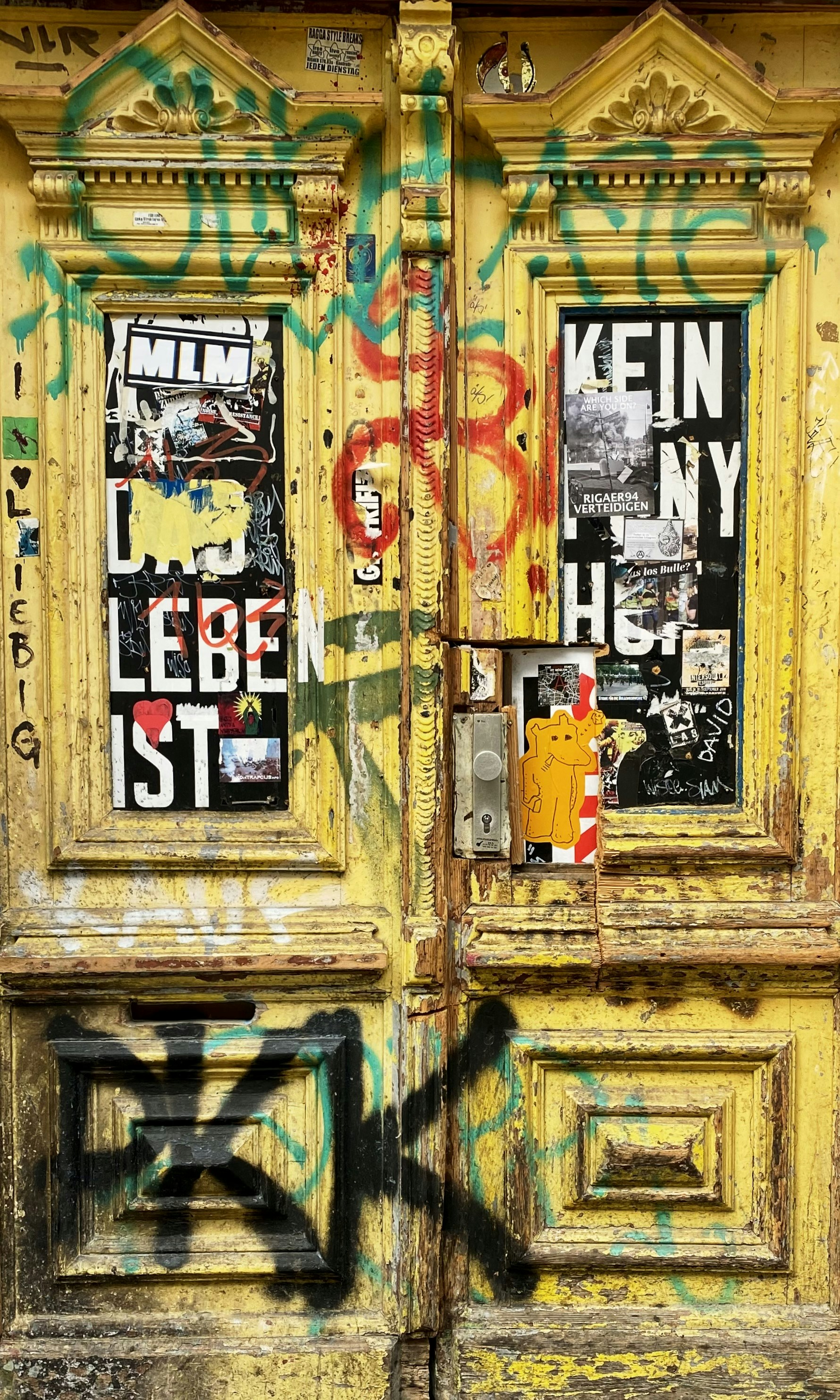 Yellow doors covered in graffiti and stickers