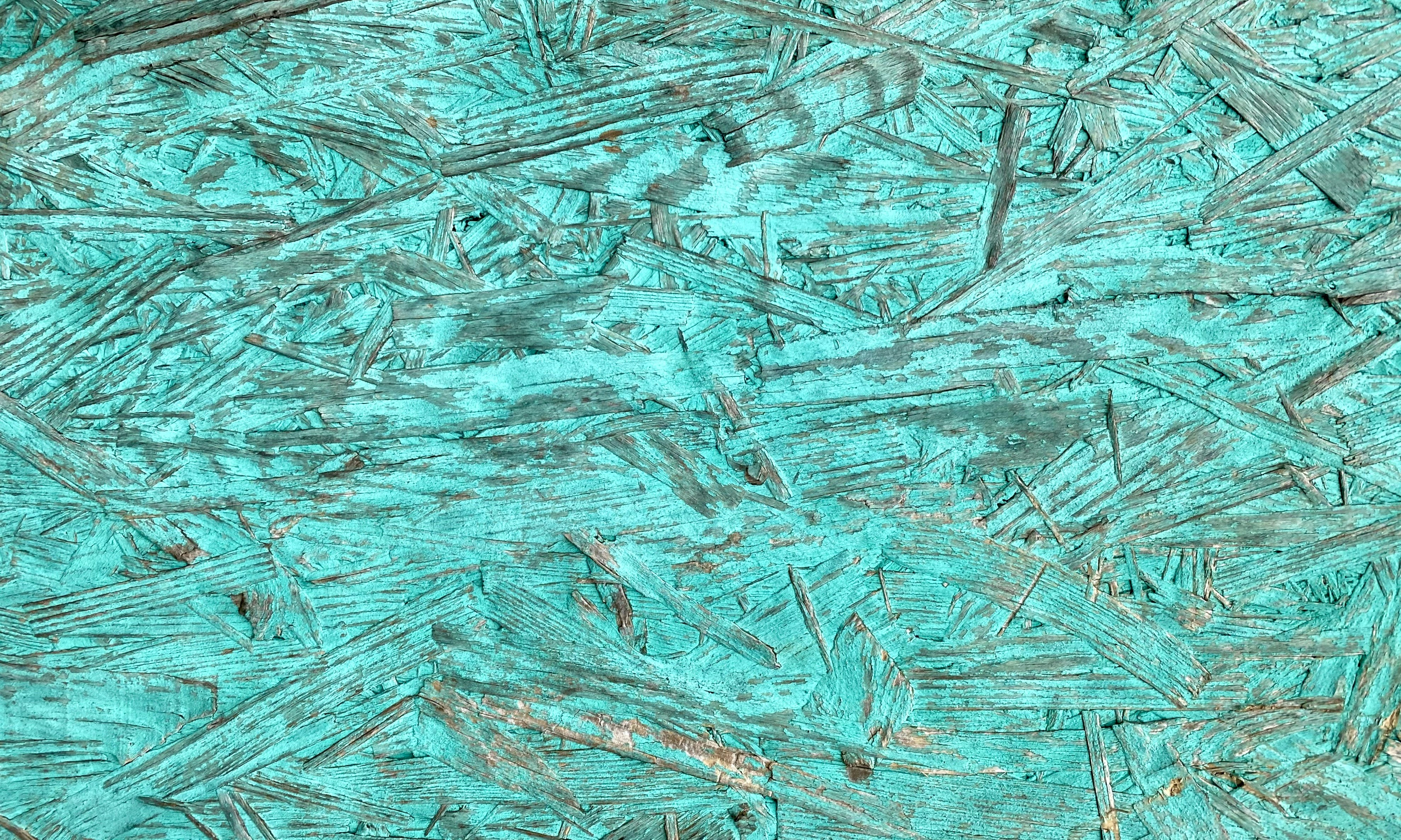 Textured turquoise surface with rough wood chips