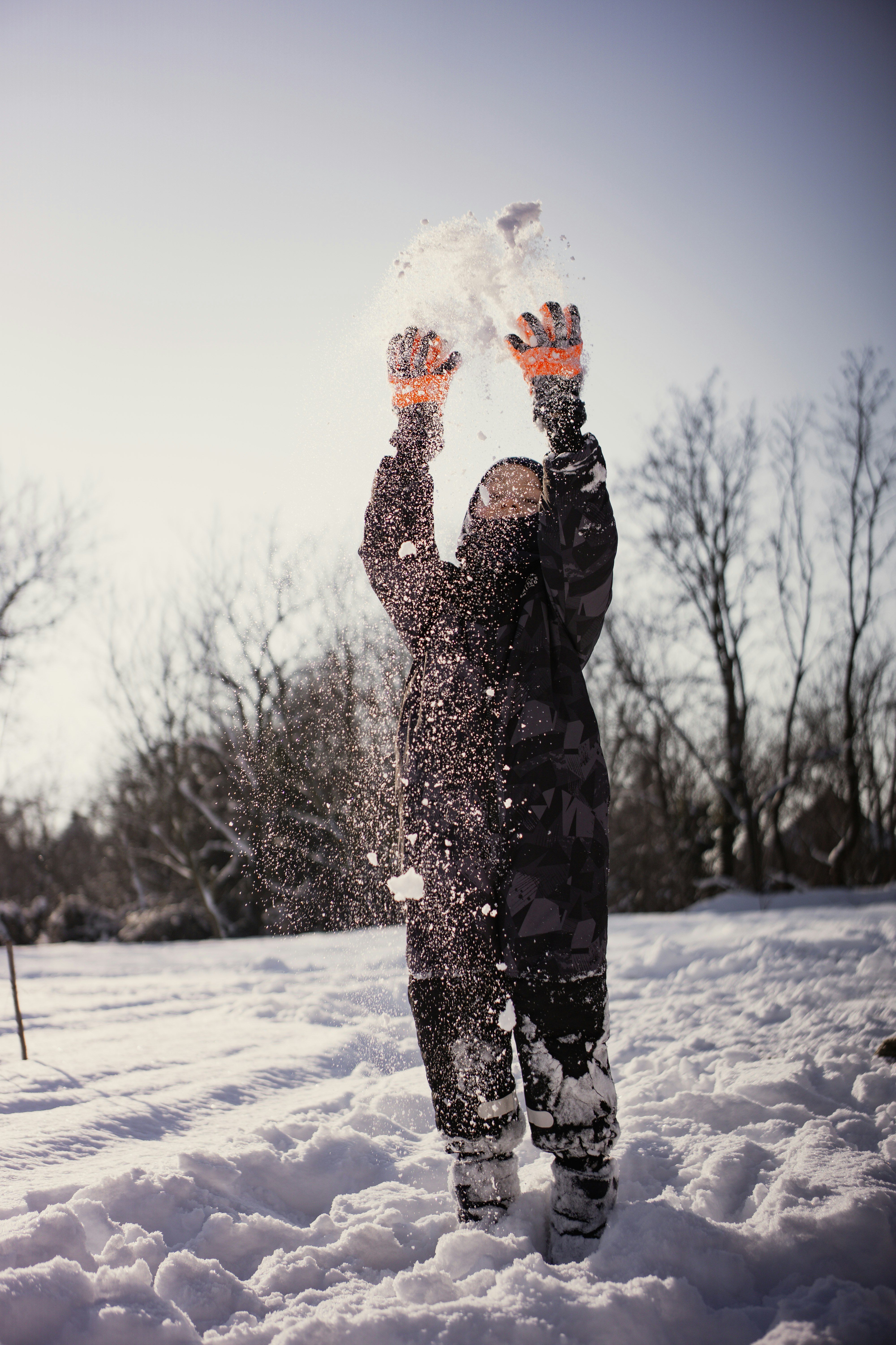 A child throws snow in the air.