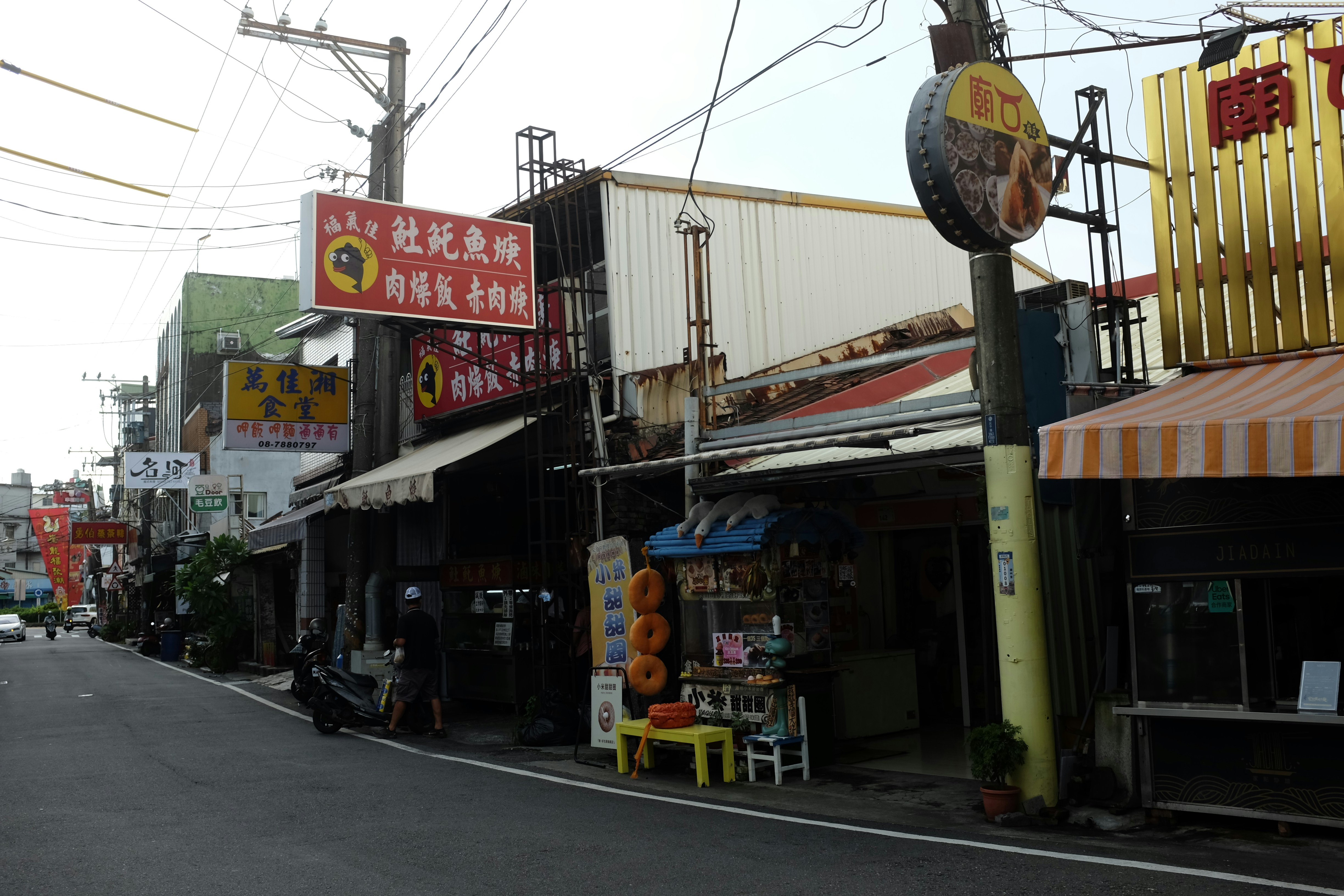 Street view of shops with signs in asian language.